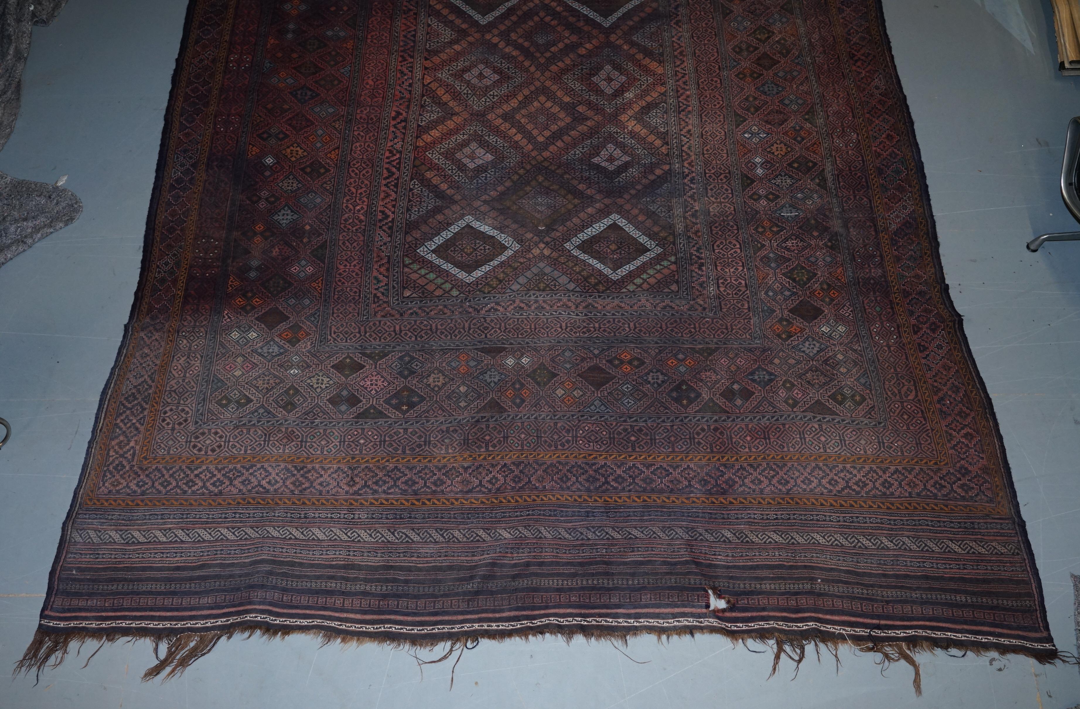 We are delighted to offer for sale this original 19th century, handwoven and knotted Kilim rug

The one is a very large Kilim, its mostly purples and is a 19th century, hand knotted and woven example, have a look at the picture of the back of the