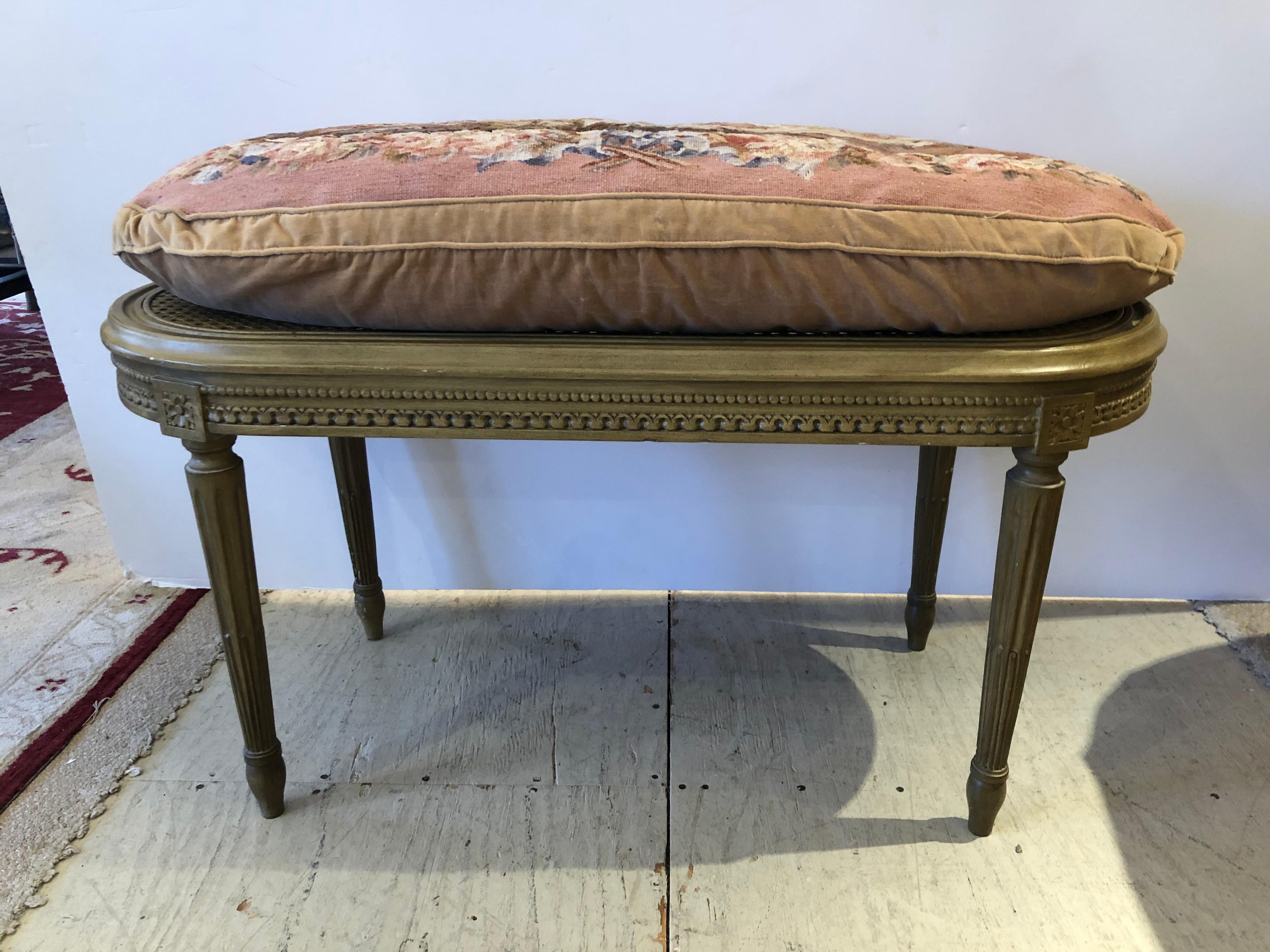 A classically pretty oval French bench having tapered reeded legs and caned seat topped with a plush hand sewn tapestry and velvet cushion. Bench without cushion is 18.25 H.