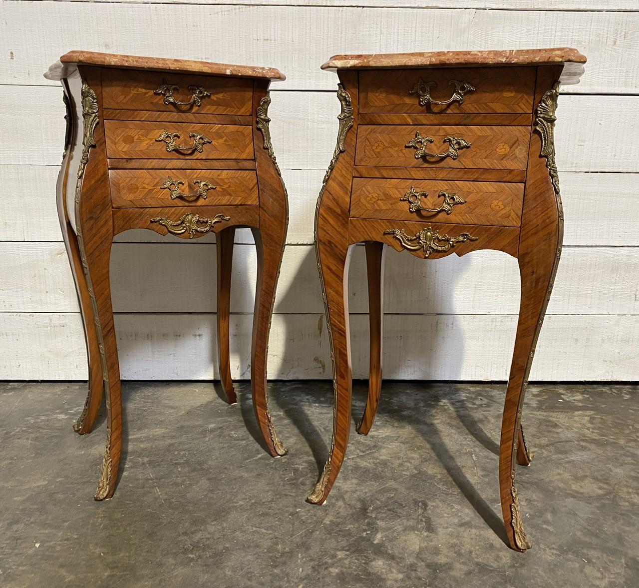 A delightful pair of French Bedside Tables, each having original perfect marble top, 3 smoothly running drawers fitted with original brass handles. Brass mounts on all sides and lovely floral marquetry. They are made from a variety of woods