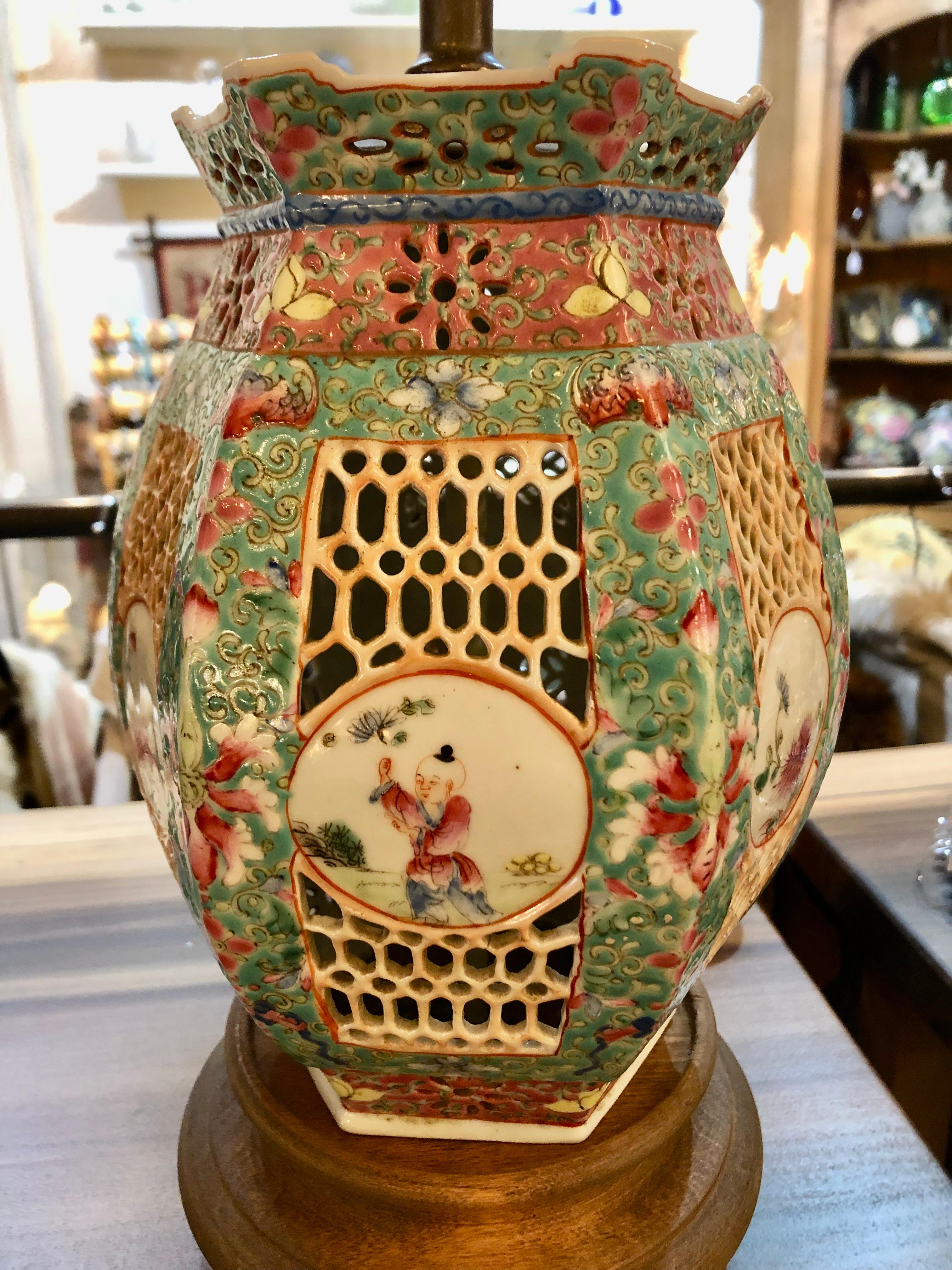 Lovely pair of Chinese porcelain table lamps having a beautiful round but angled shape and gorgeous color palette of celadon, pink, gold and cream. Detailed round paintings of figures and flowers as well as lattice cut out design are splendid.