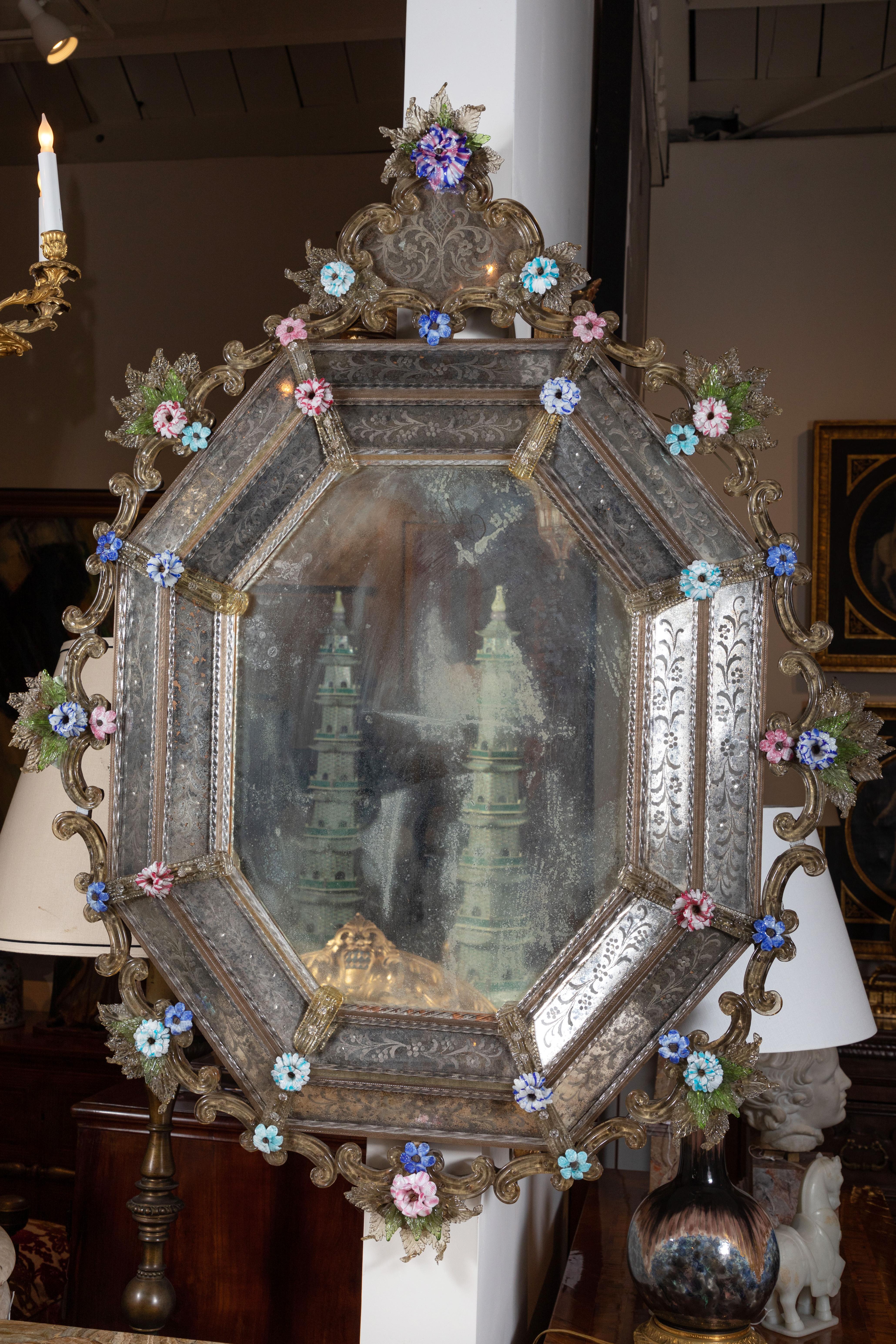 An exceedingly rare, circa 1800, etched, Venetian, octagonal mirror surrounded by scrolling glass brackets embellished by detailed, hand-colored, hand-blown glass blossoms and leaves. The whole surmounted by a large, matching medallion of the same.