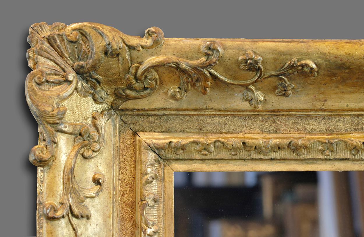 A extremely rare and very fine 2nd quarter of the 18th century hand carved French Provençal Louis XV frame. The frame has an ogee profile with frieze and is carved with a leaf-tip-&-flower sight; corner-&-centre cartouches with foliate sprays,