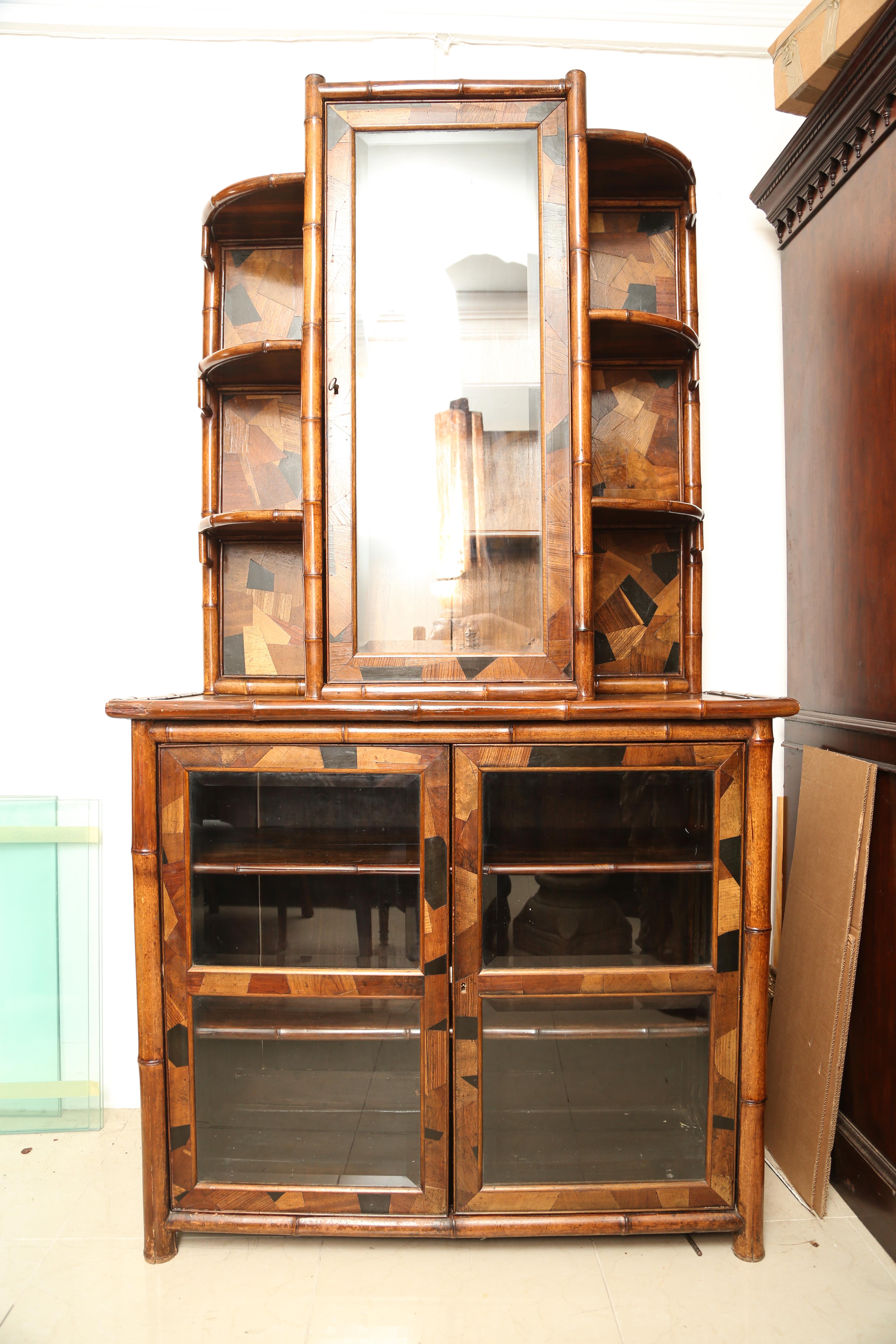 This is a superb quality original antique bamboo bookcase with 2 doors below and one above.
In the arts and crafts style.
There are many pieces of wood ranging from ebony, oak, pollard oak, mahogany, beach etc all individual inserted.
There are 2
