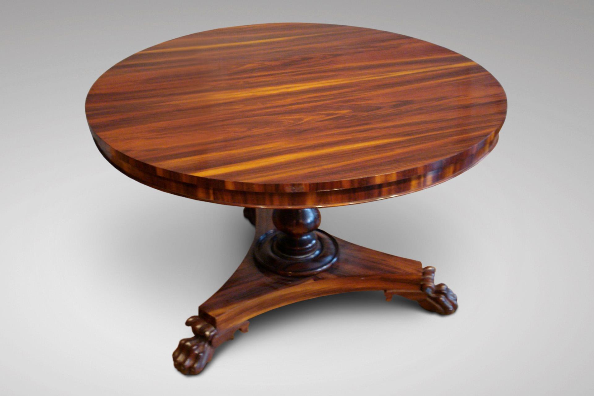 An unusual 19th century centre table in Goncalo Alves, sort of rosewood with a circular tilt-top, turned baluster stem and a concave sided trefoil platform raised on scroll carved claw feet with concealed castors. England circa 1830. Superb quality.