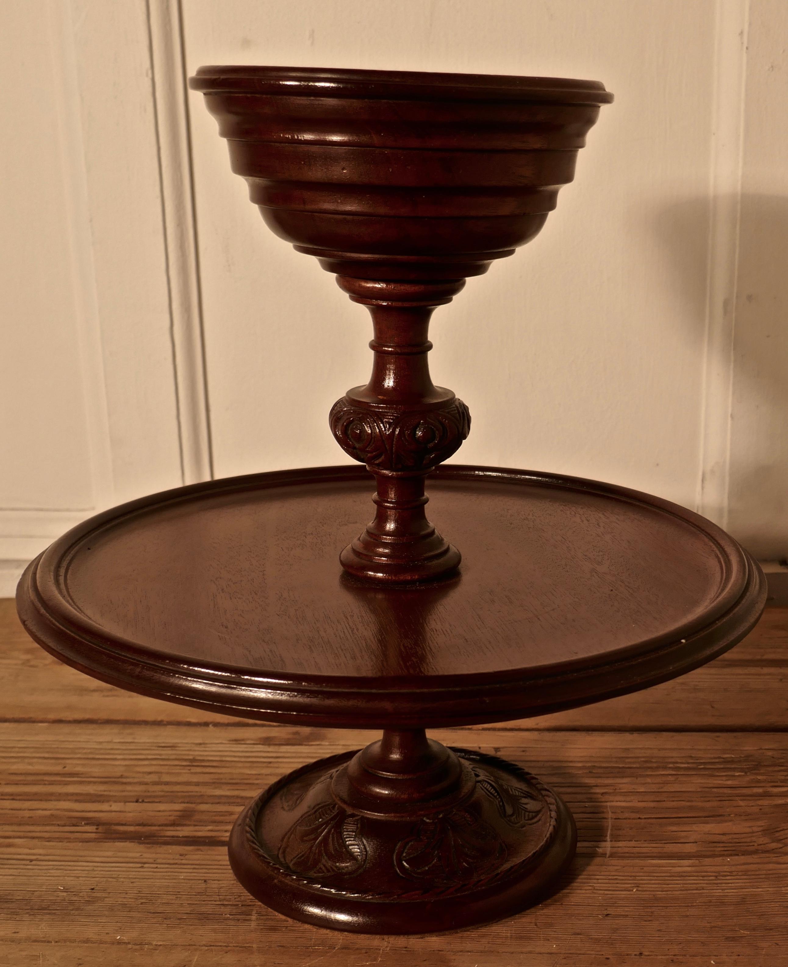 Very rare 2-tier mahogany Lazy Susan

A superb piece with a main tier in the centre and bowl at the top. The centre column is decoratively carved and the lower tier has pie crust edge all in very smooth working order
The stand is 14” tall and 13”