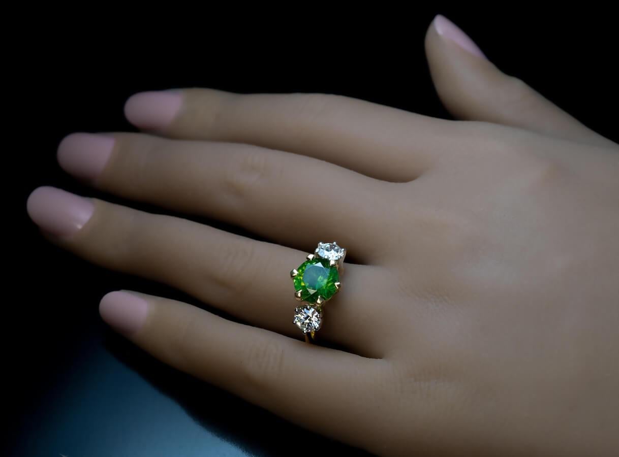 This contemporary three stone 18K yellow gold and platinum ring features a very rare 3.51 ct Russian demantoid from the Ural Mountains. The demantoid is flanked by two perfectly matched diamonds (0.54 ct and 0.54 ct, H color, SI1 clarity, excellent