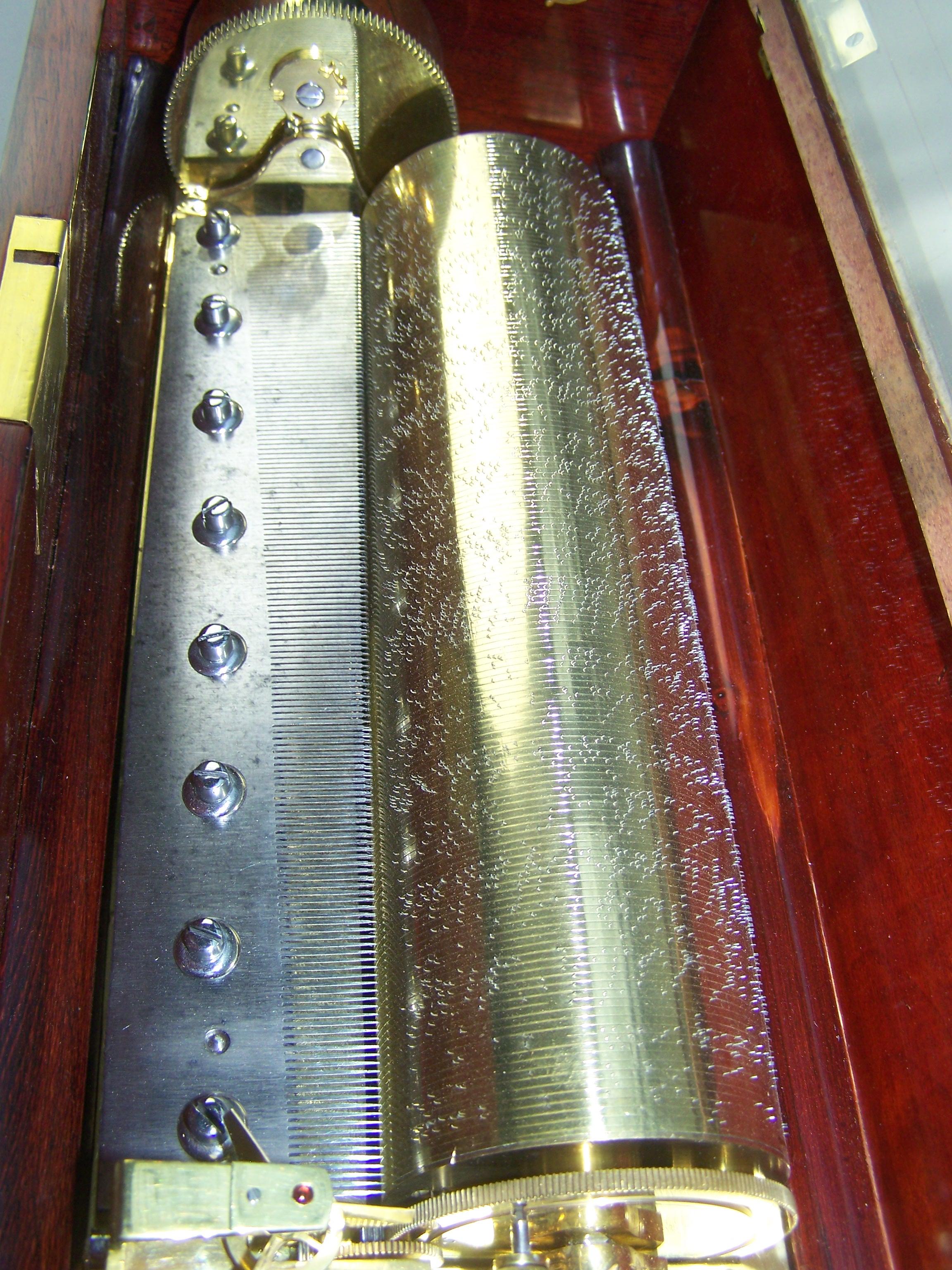 Sehr schöne und frühe Ouvertüre-Spieldose, wahrscheinlich von Lecoultre (allerdings unsigniert).
Der Klappenwindmechanismus spielt 4 Ouvertüren mit einem schönen und hellen Ton auf einem sehr feinen Kamm. Der Fadenzylinder ist 29 cm lang.
Der Deckel