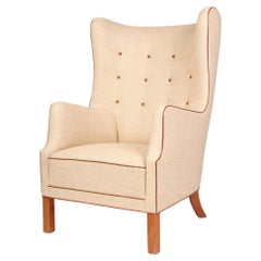 Vintage Danish wingback armchair with off-white canvas, Niger leather details, elm legs