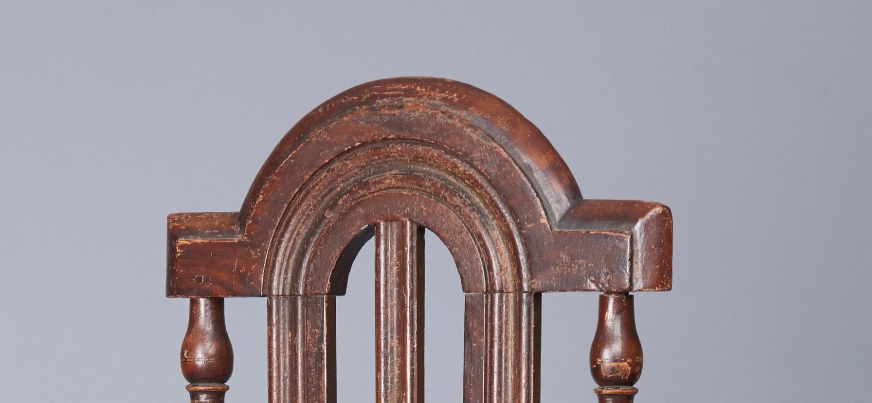 Arched crest, good turnings, molded splats, rush seat. Turned legs terminating in ball feet. Wonderful old grained paint and patina. Pennsylvania, circa 1730-1740.