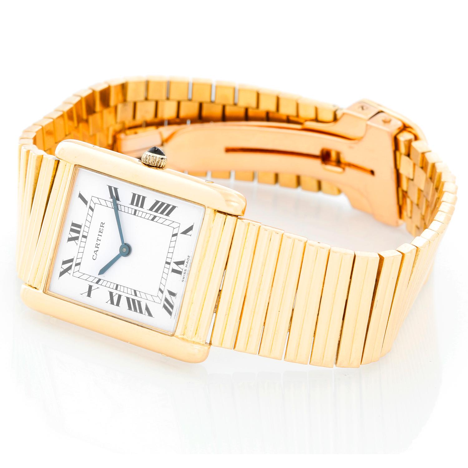 Very Rare Cartier Tank Paris 18K Yellow Gold Watch - Manual. 18K Yellow Gold ( 26 x 34 mm ). Ivory dial with black Roman numerals. 18K Yellow gold integrated bracelet with deployant clasp; can be sized. Can fit up to a 7 inch wrist. Pre-owned with
