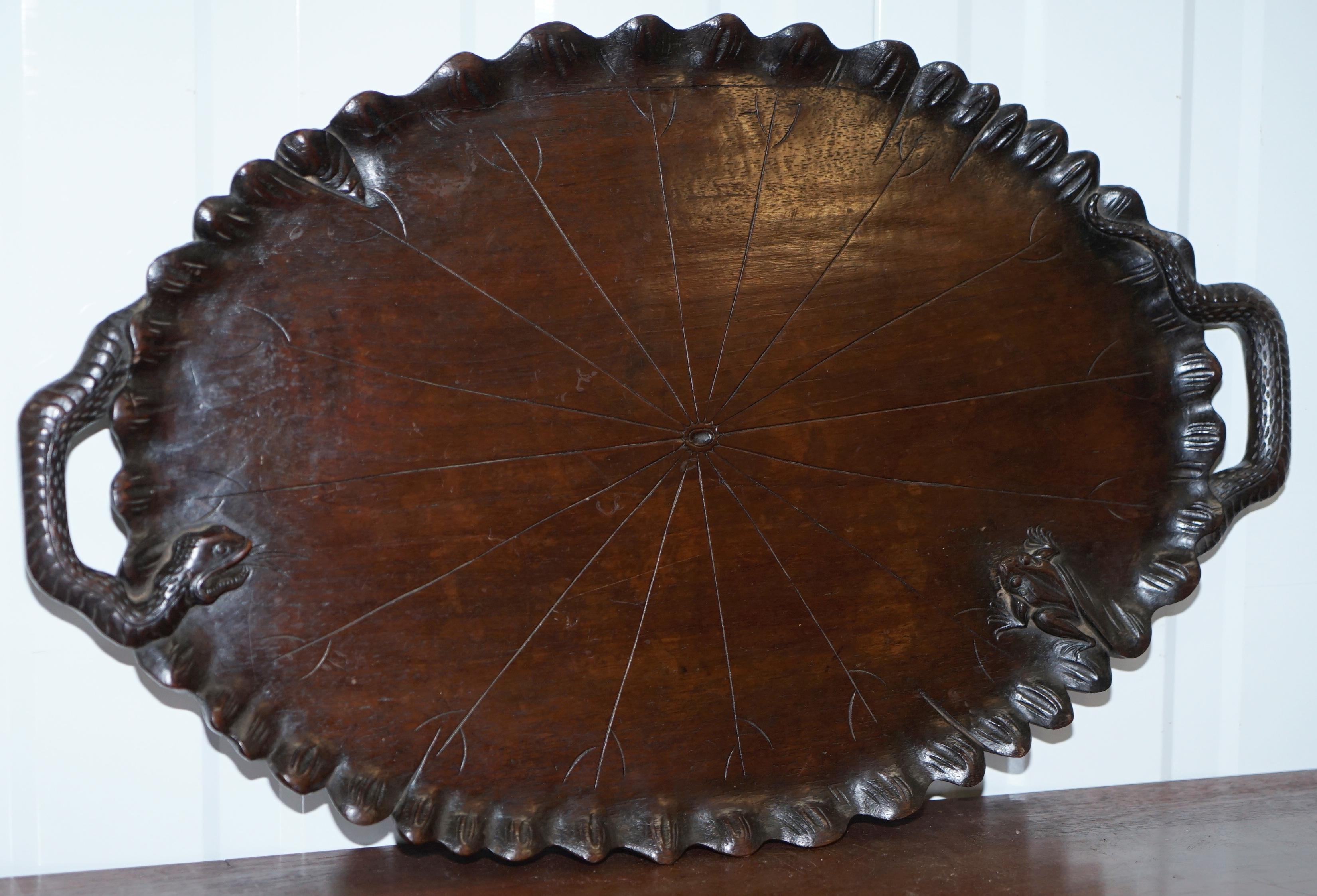 We are delighted to offer for sale this very rare circa 1850 hand-carved from a single piece of timber serving tray with snake handles chasing a frog

A very good looking and exquisitely carved piece, the handles are made up of the snake's body