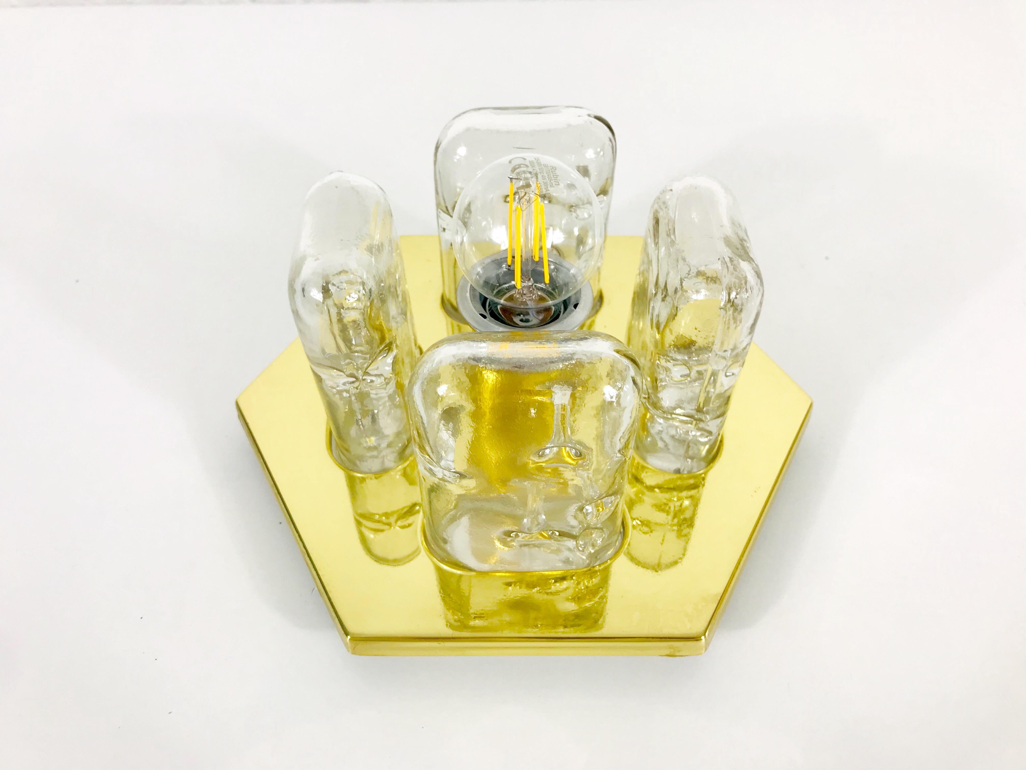 A Doria ice glass flush mount made in Germany in the 1960s. It is fascinating with its rare glass shape. A brass body with a brass bar. 

The fixture requires one E27 light bulbs.
 