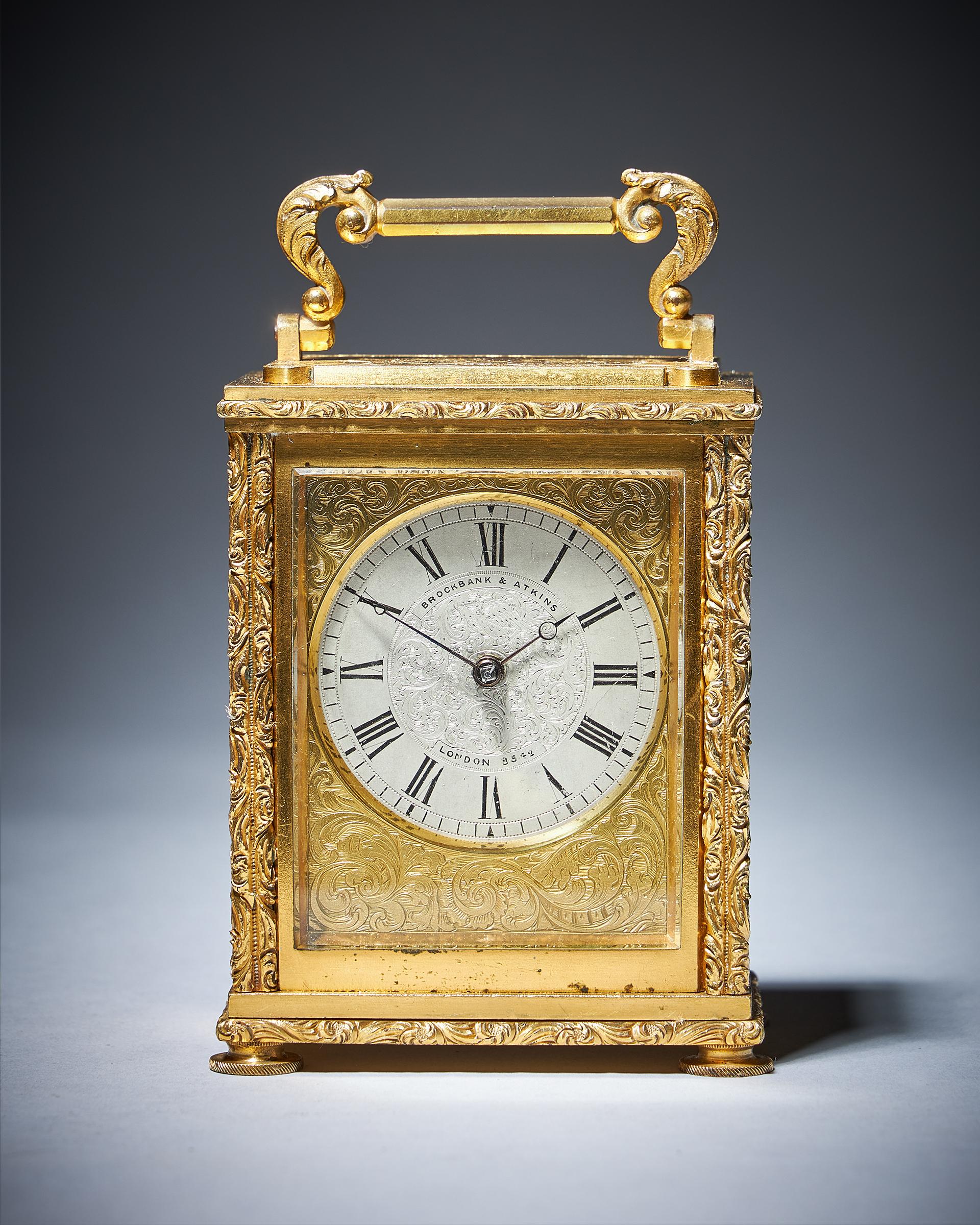 A very rare small nineteenth-century carriage clock signed and numbered on the silvered dial BROCKBANK & ATKINS LONDON 8542, c. 1830-1840. England

The extremely attractive engraved and gilt brass case of small proportions has four chased shaped