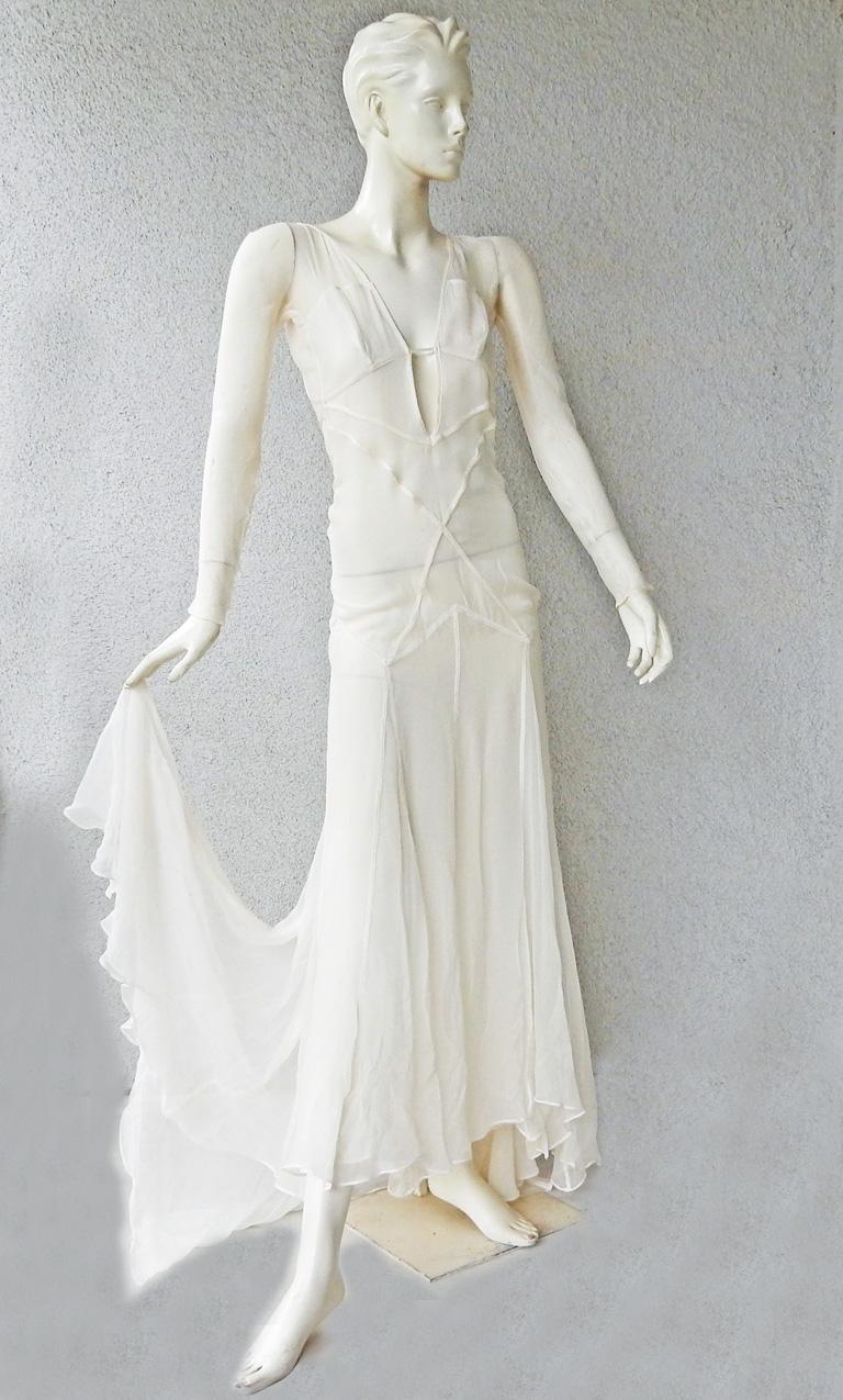 A rare Gucci by Tom Ford 2002 evening dress fashioned in eggshell white outlined in eye catching seam illusion.   Dress boasts a tasteful plunging neckline extending into a full skirt with dramatic train.   Criss-cross design open back.  Side snap