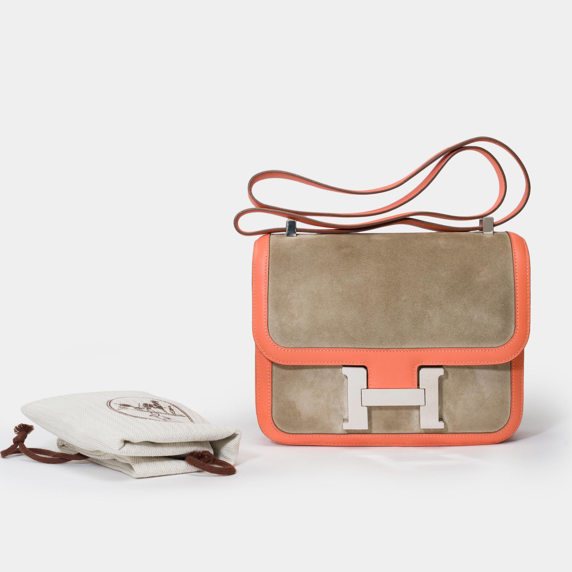 Rare & Exceptional Hermès Constance 23 limited edition in Grey Tourterelle Calf Doblis and Crevette swift leather , metal palladium silver trim, a shoulder strap in pink leather allowing shoulder or crossbody carry

Logo closure on flap
Pink leather