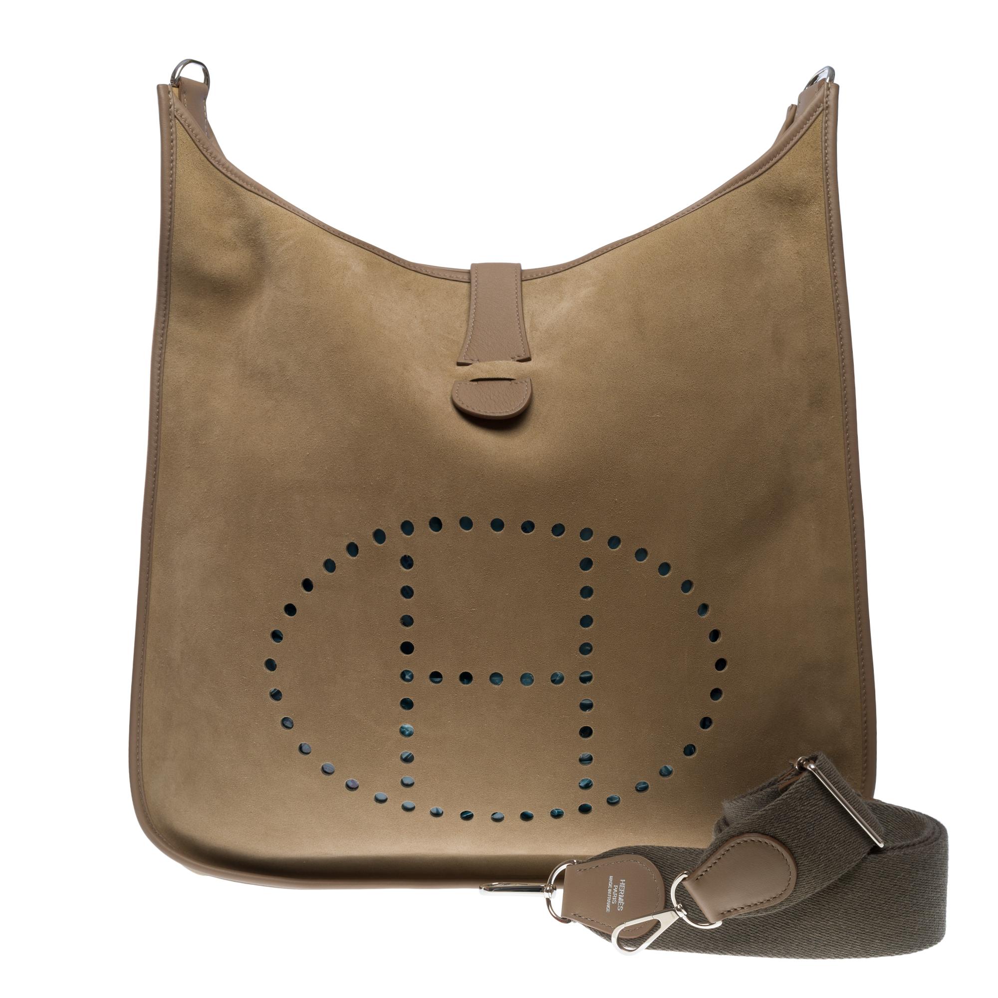 The Iconic & Very Rare Hermes Evelyne TGM shoulder bag in étoupe Doblis Suede, palladium silver metal hardware, a removable adjustable shoulder strap in gray canvas allowing a shoulder or crossbody carry

A patch pocket on the back of the bag
Snap