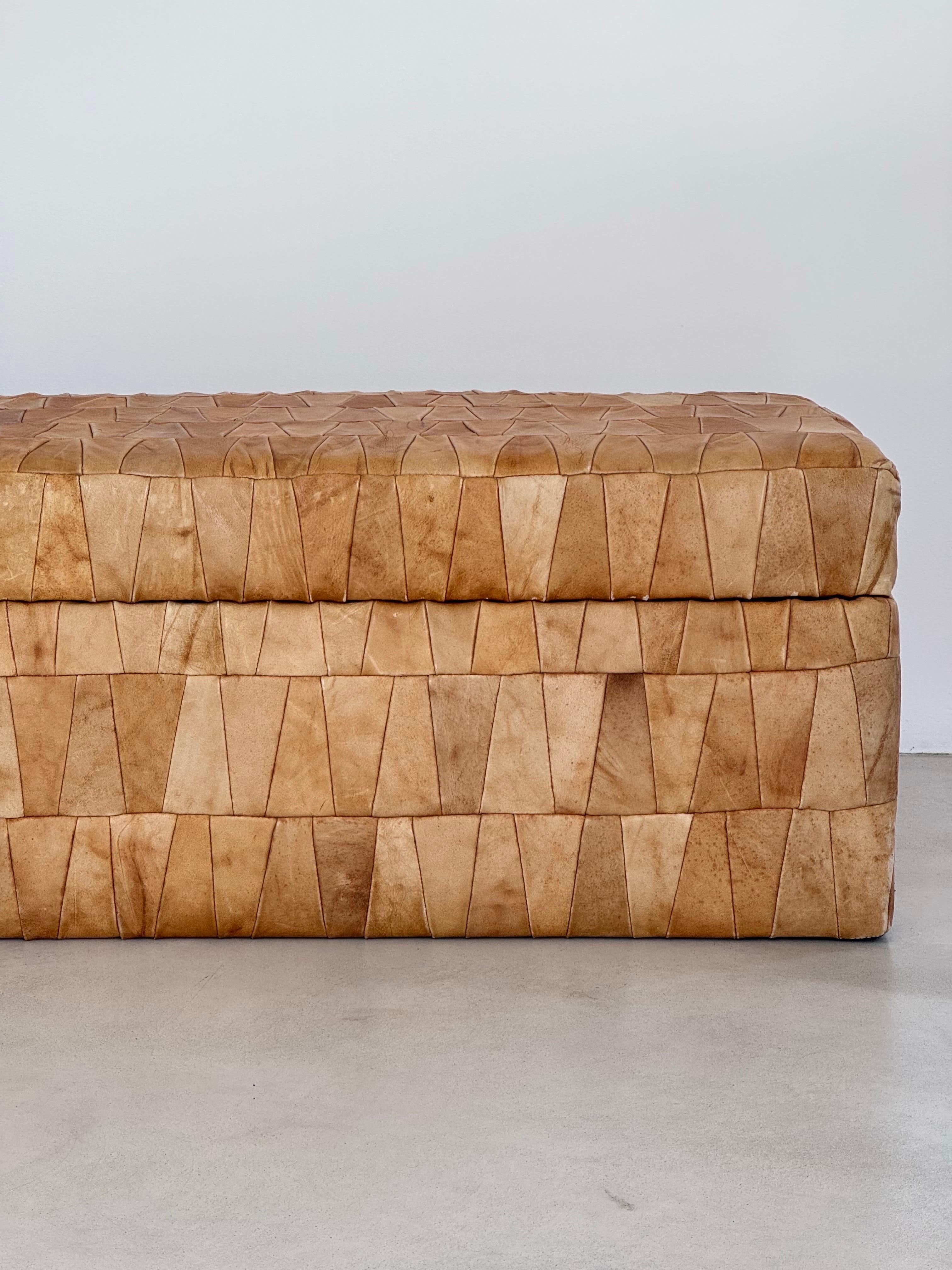 The timeless elegance of this huge leather patchwork storage ottoman by De Sede, an iconic piece of 1970s design. This stunning furniture item perfectly combines functionality and aesthetics, adding a touch of vintage sophistication to your