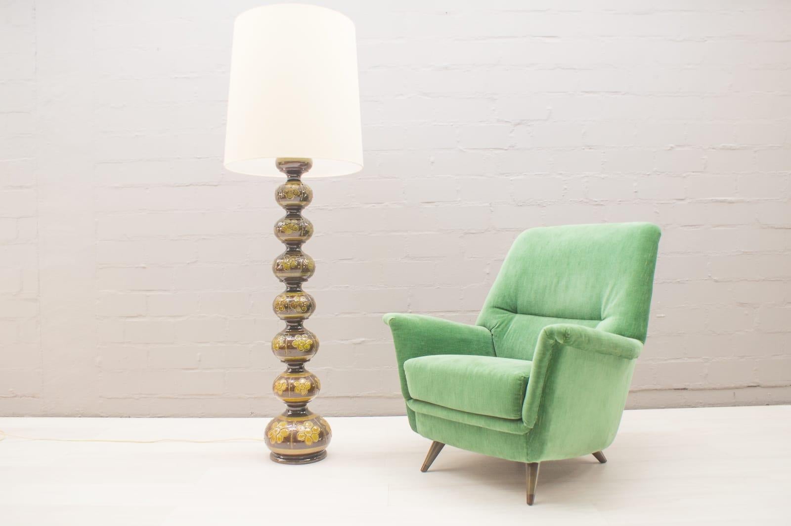 These ceramic floor lamps were designed in the 1960s. 
The skylight and the two inner lights can be turned on separately. 
We have had the lampshades reupholstered.
We have two more floor lamps and several table lamps from Kaiser Leuchten.