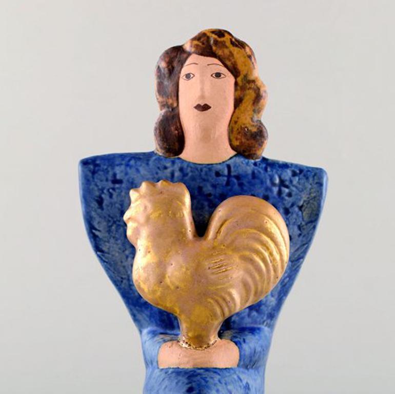 Very rare Lisa Larson unique figure of sitting woman in blue with golden rooster.
Signed.
Measures: 21 x 10 cm.
In perfect condition.