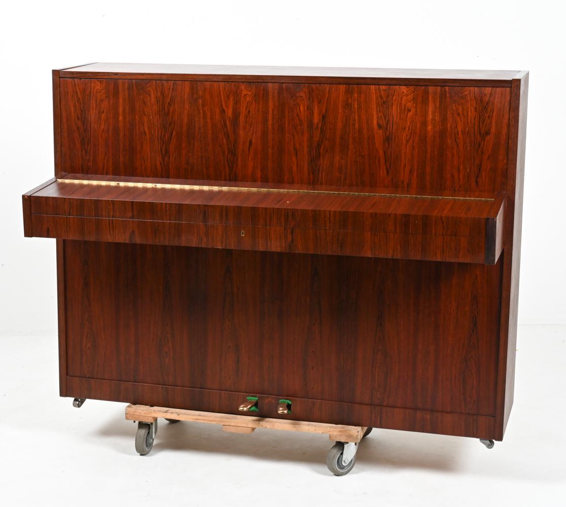 Presenting an extraordinary find for the discerning musician and design enthusiast alike – a rare Louis Zwicki upright piano in exquisite rosewood. This stunning piece, crafted in Denmark, stands as a testament to the artistry and precision that