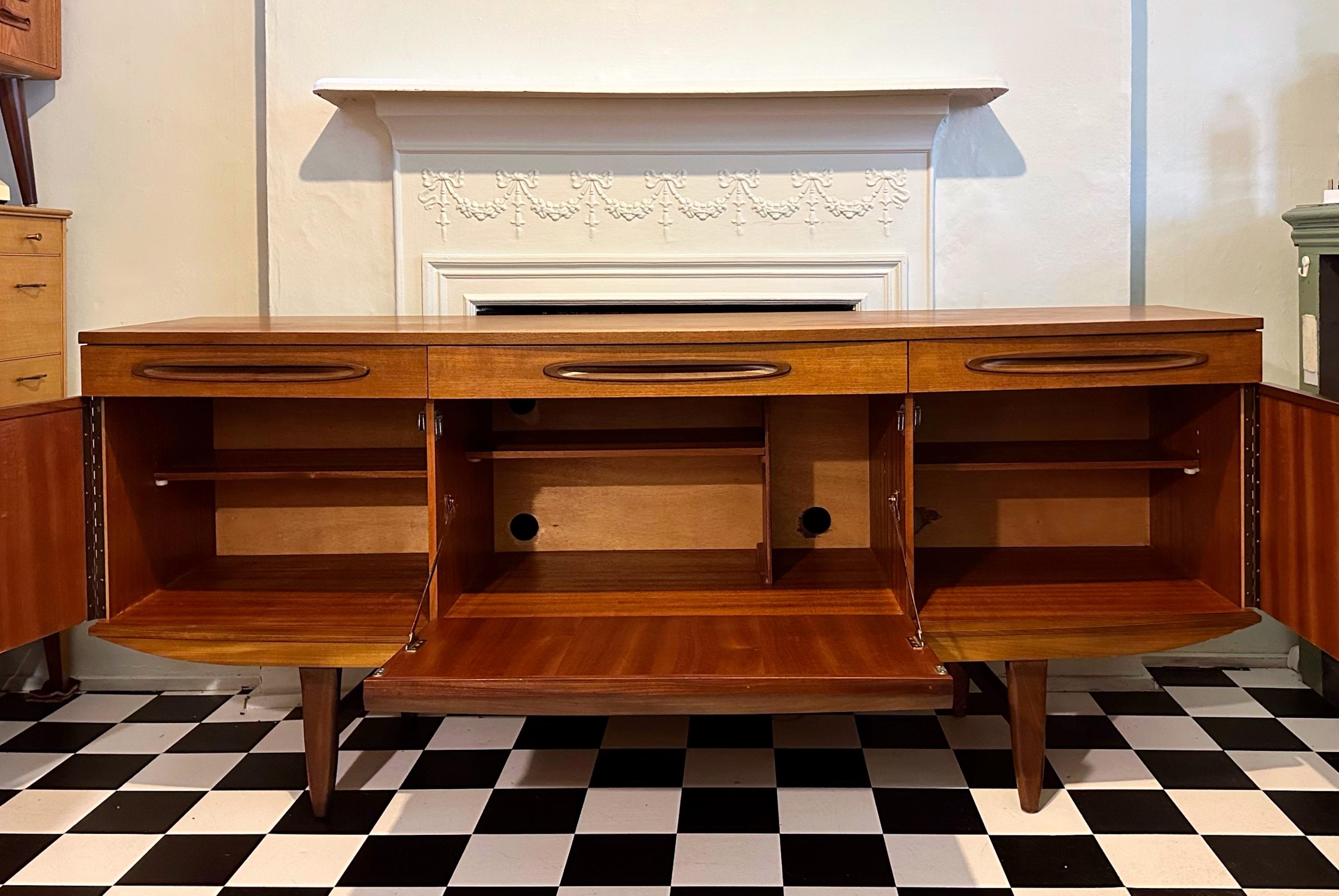 Beautiful and very rare mid-century teak sideboard. Designed and crafted in 1960's by Elliott’s of Newbury (EoN). Curved front of this stunning sideboard makes it very unique. Fully refurbished and ready for a new home. This sideboard features three