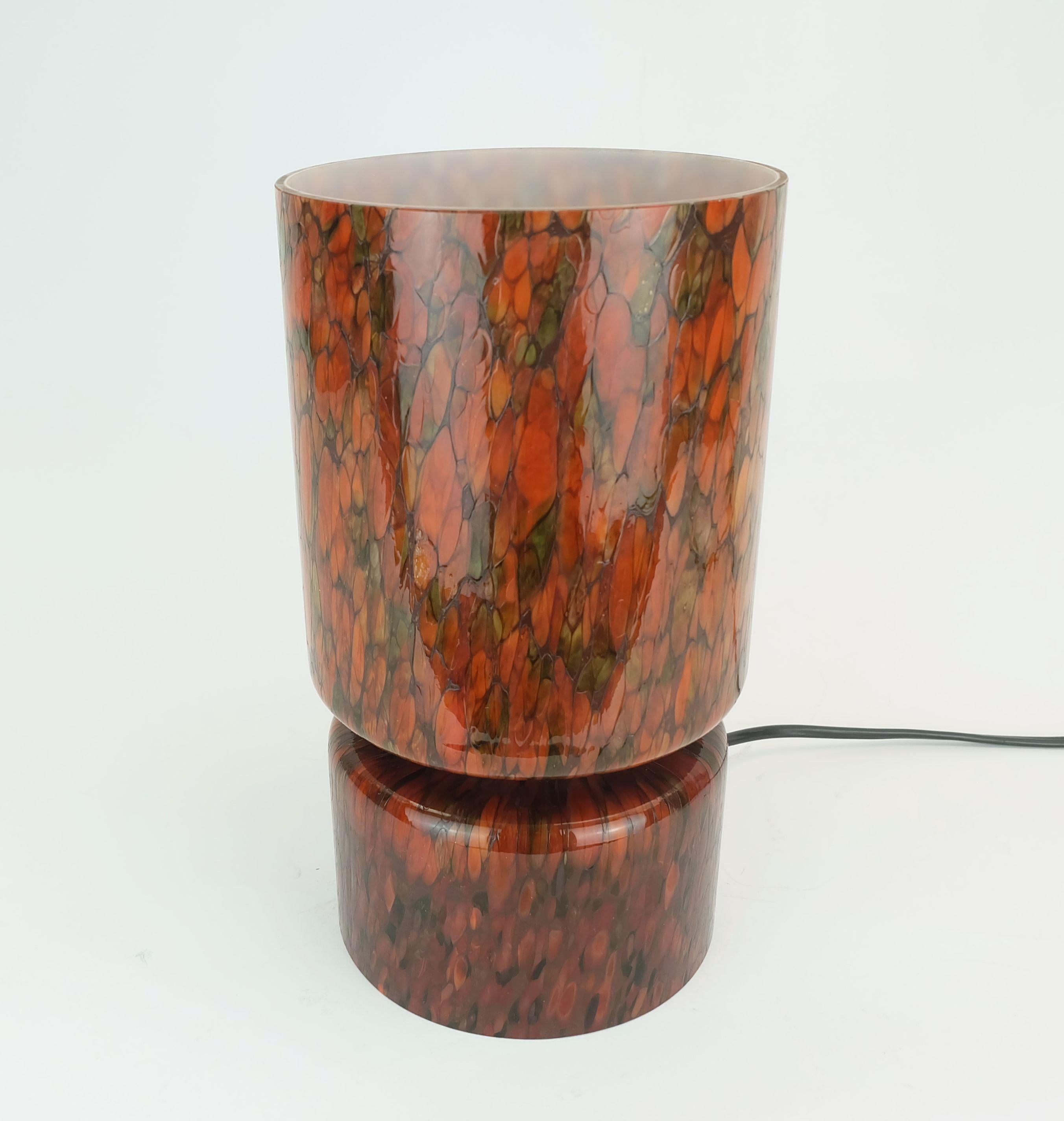 Preciosa lámpara de sobremesa fabricada por Peill & Putzler entre los años 1960 y 1970. Vidrio blanco, recubierto de color en tonos naranja y verde mediante una técnica millefiori. Para una bombilla E27. Efecto luminoso muy agradable y suave.