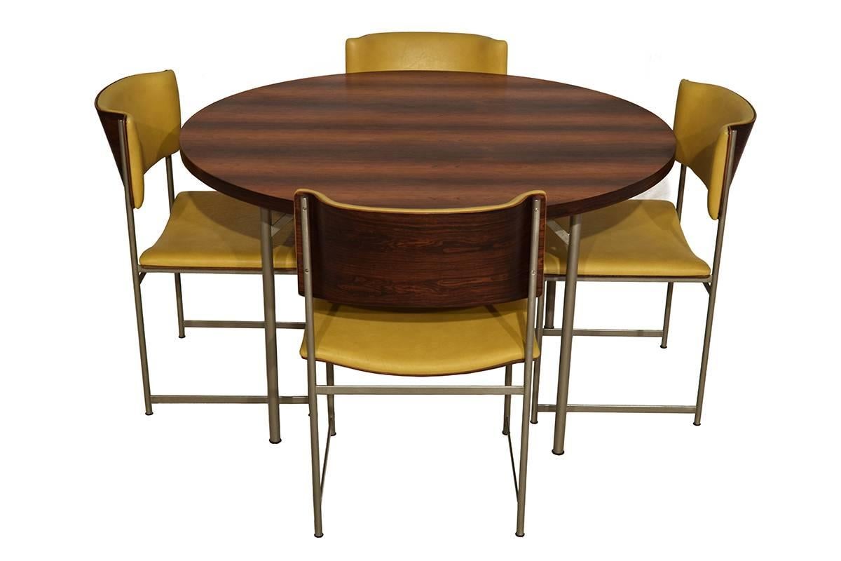 One of a kind Mid-Century Modern rosewood dining set designed by the Dutch Modernist Cees Braakman for Pastoe in the 1960s. The chairs still have the original yellow faux leather. The measurement of the table is 120cm x 71 cm. An exceptional set.