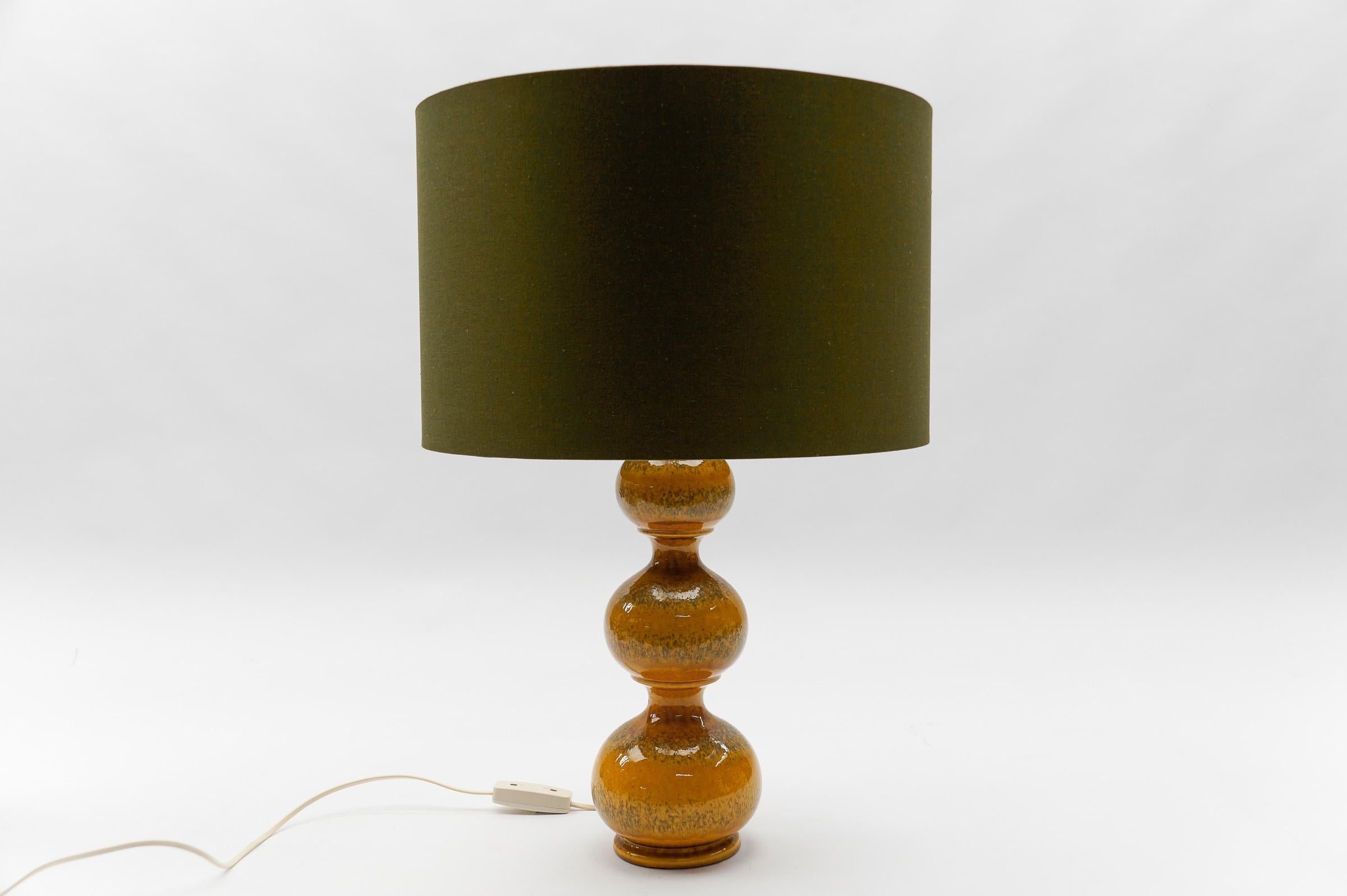 Diese Tischlampe aus Keramik wurde in den 1960er Jahren entworfen. 

Wir haben insgesamt sechs Tischlampenfüße aus der Keramikserie Kaiser Leuchten Bubble aus den 1960er Jahren. 

Drei große orangefarbene, eine etwas kleinere und zwei größere grüne.