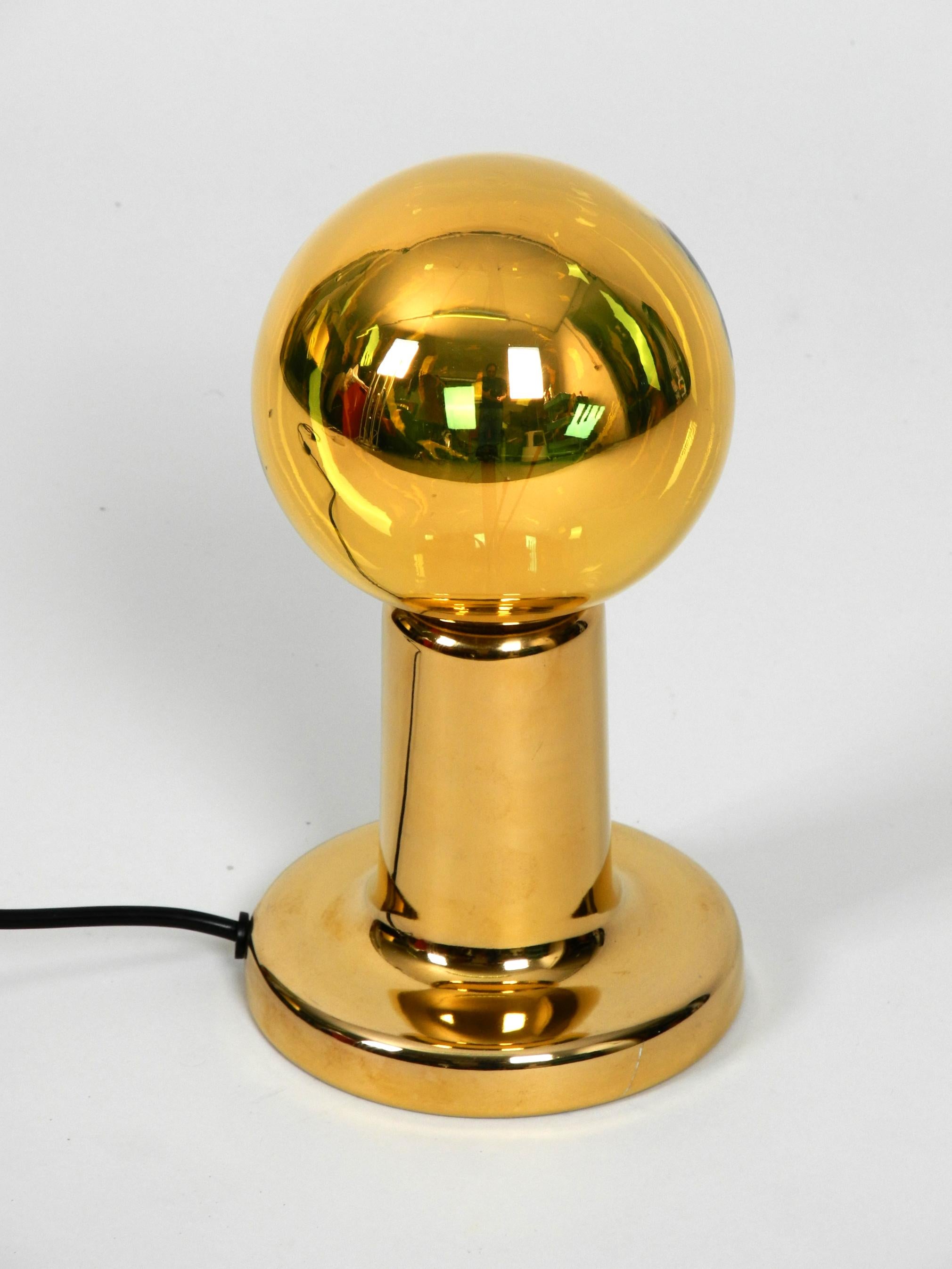 Very rare original 1970s Pop Art Phillips NTD ceramic table lamp 
in high glossy golden color.
Great Minimalist design with the big golden mirrored light bulb.
Very good vintage condition without signs of wear. 
Only a small paint scratch on the