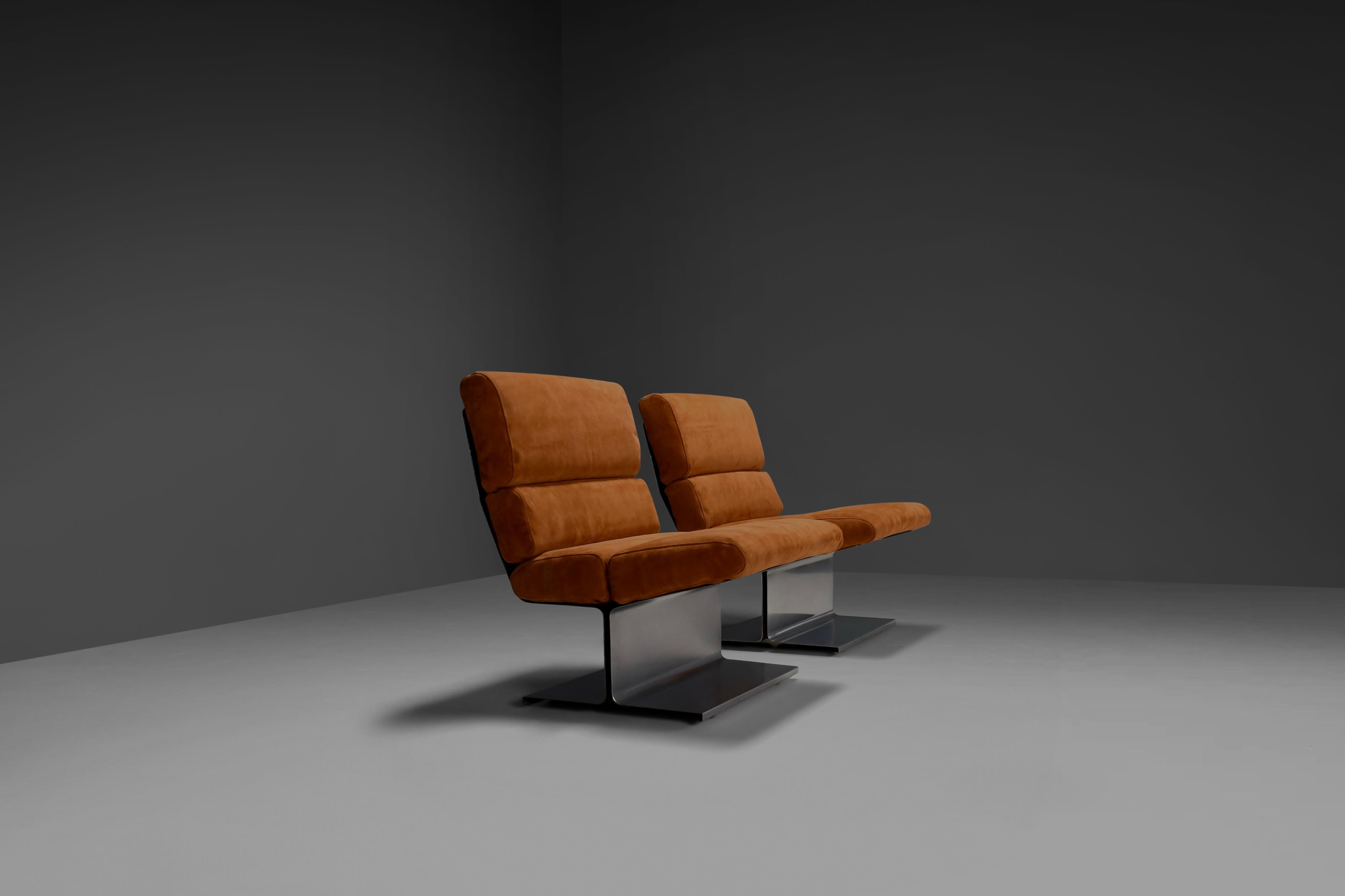 Iconic pair of lounge chairs in excellent condition.

Deigned by Paul Geoffroy and manufactured by Uginox in the 1970s in France.

Striking design composed of curved stainless steel frames with beautiful shaped cushions. 

The cushions are