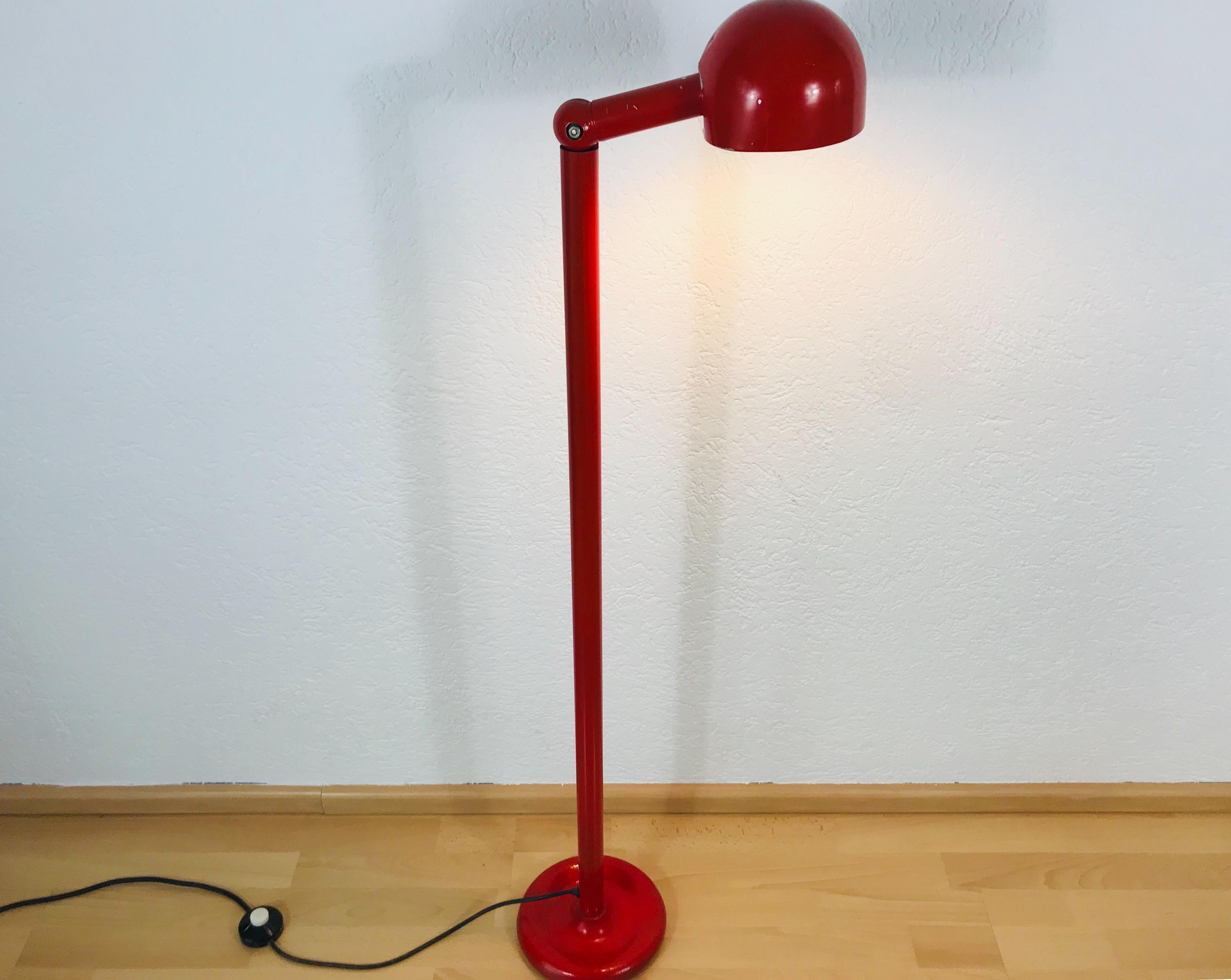 An exceptional floor lamp by Stilnovo made in Italy in the 1960s. It is fascinating with its unique design and amazing red color. Adjustable head with beautiful patina. The bottom and the bar are made of metal including the head. The original brand