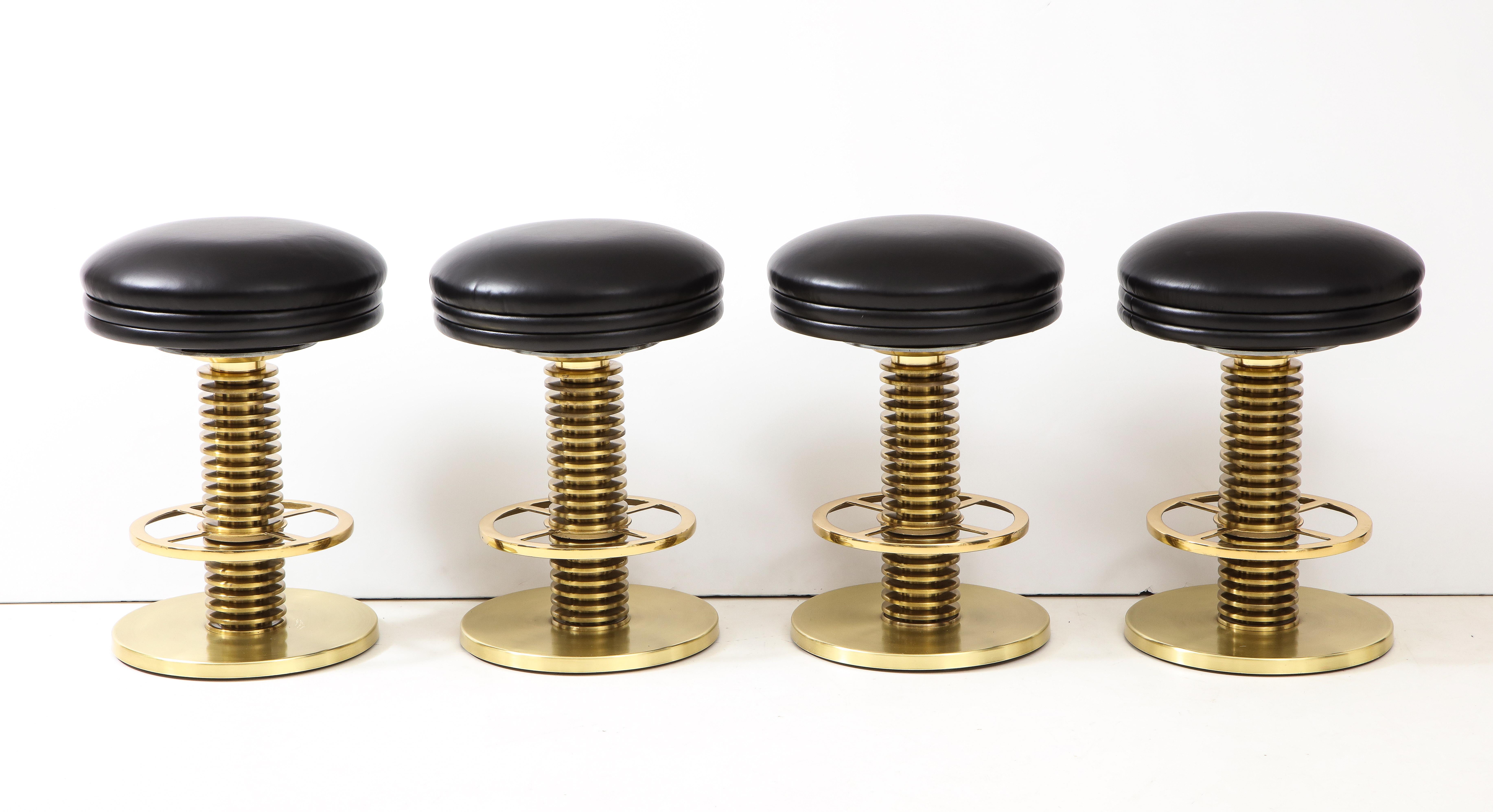 Very set of 4 brass stools by Designs for Leisure.
This unusual custom set of stools have been newly reupholstered in a smooth black leather.
The swivel seats sit on a stacked column base with a polished brass foot rest.