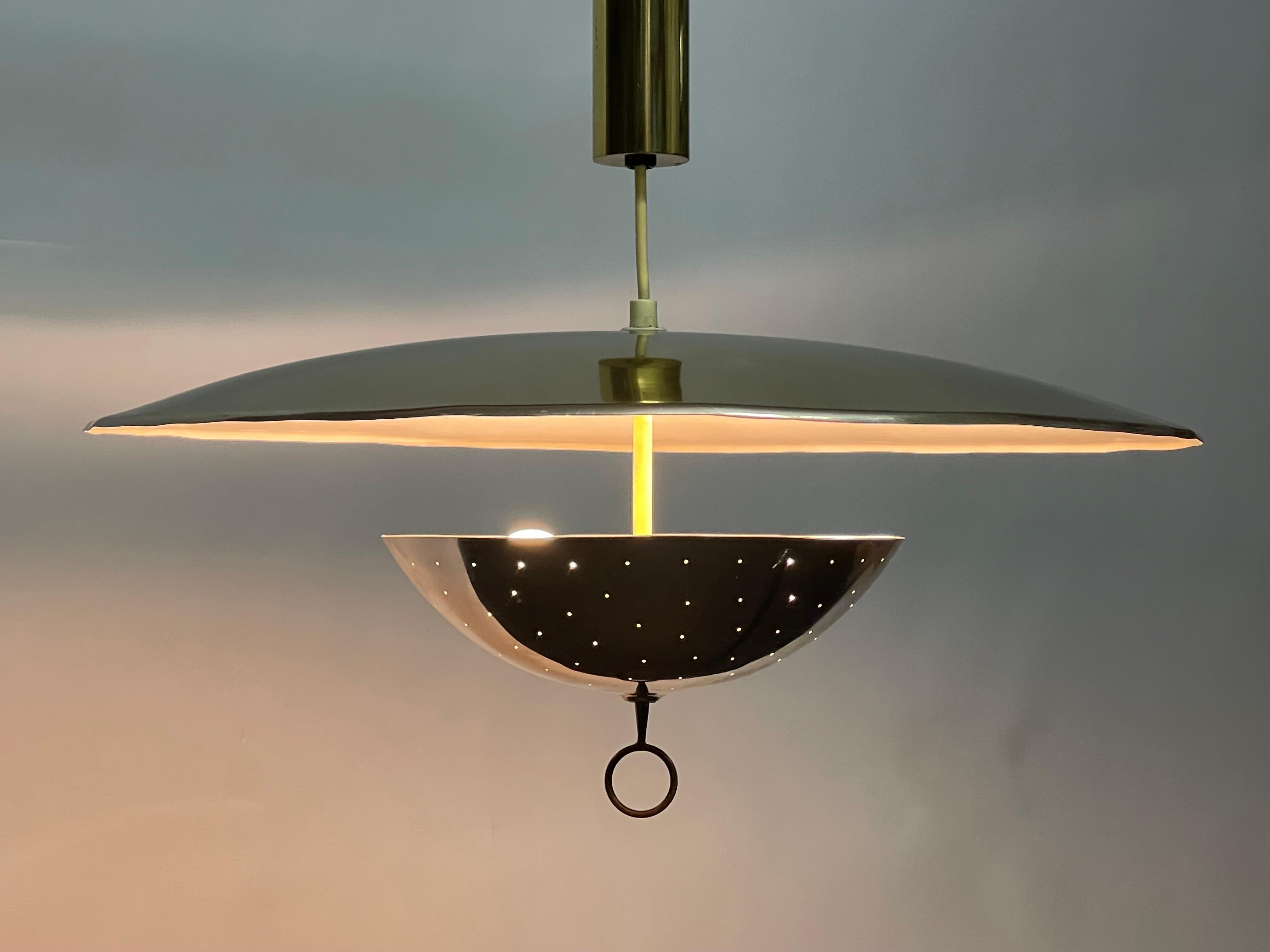 A very rare pendant lamp by Gino Sarfatti for Arteluce, Italy, circa 1950s.
Cup-shaped reflector in white lacquered and coppered aluminium. Counter cup in perforated and nickeled brass.
Ceiling fitting, handle and counterweight in polished brass