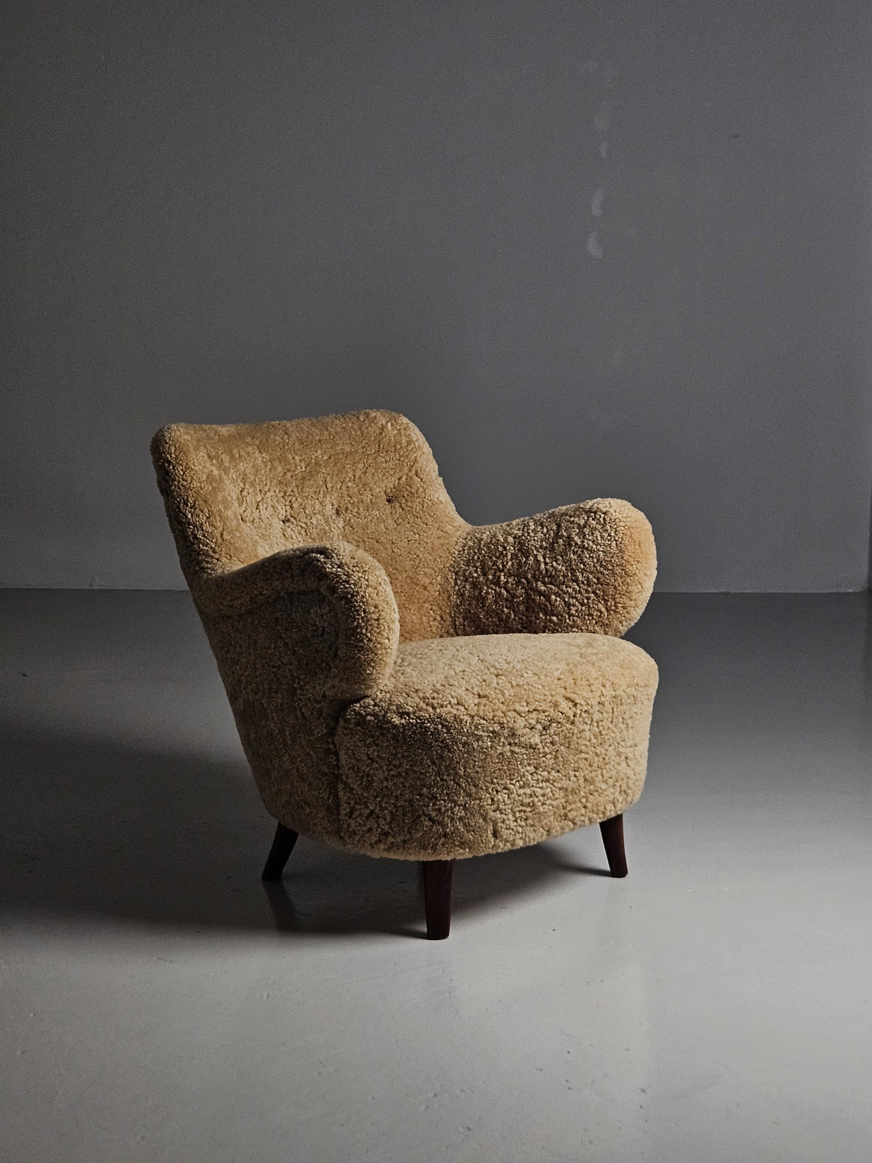 Scandinavian Modern lounge chair designed by Gustav Axel Berg and produced by his own firm AB G.A. Bergs, Sweden, in the 1940s. 

Legs of beech and upholstered in honey colored sheepskin. 

Extremely rare model. 