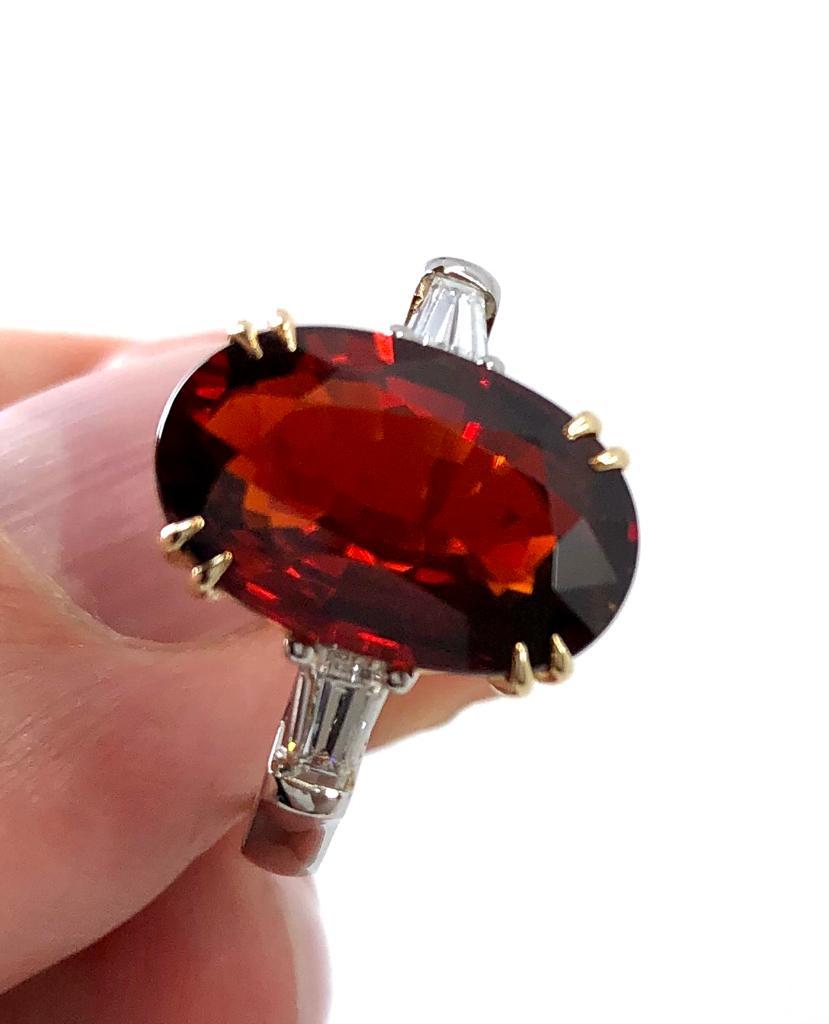 Very rare , untreated 6,39 ct clinohumite exhibiting a beautiful red orange collaboration is a center gemstone in this classic ring. 
This absolutely unique gem is GIA certified including notable letter exhibits excellent transparency and superb