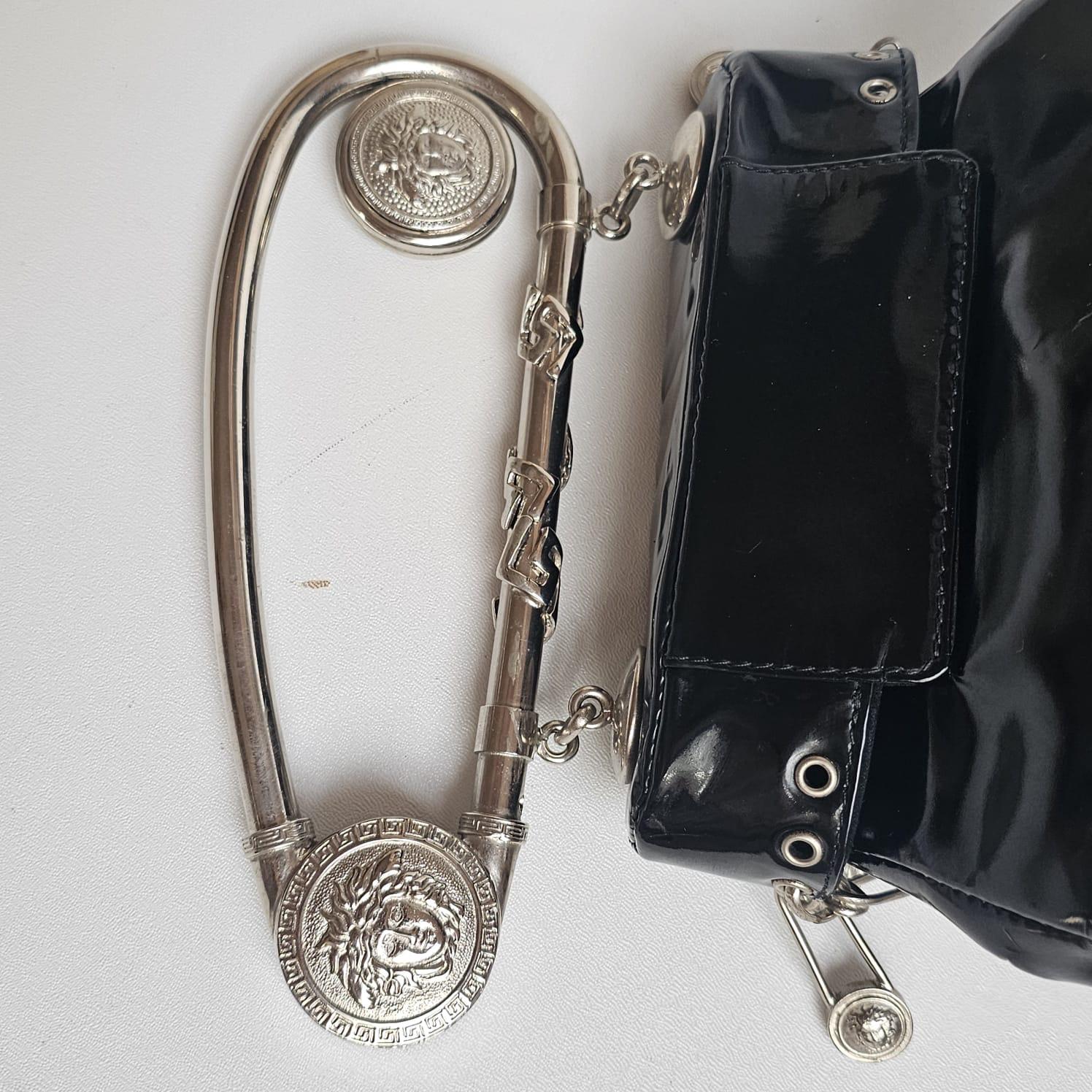 Archival Versace piece from 1994 collection. Item shows slight marks on the patent leather as seen on pictures due to storage. Slight cloudiness throughout the patent surface and minor crack on the buckle closure area but nothing significant. Faint