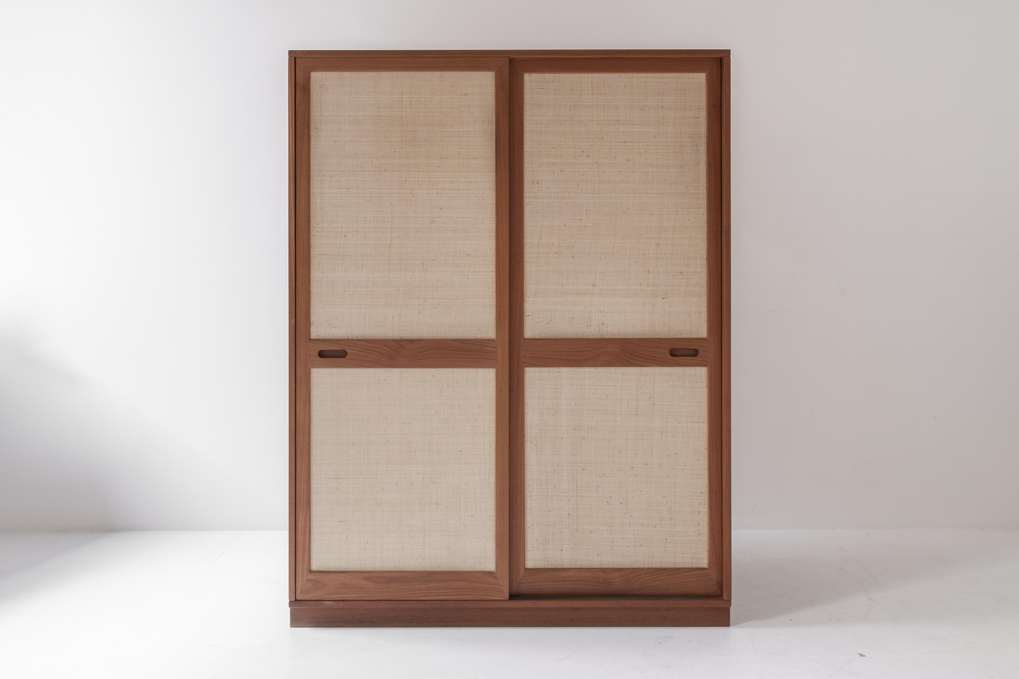 Very rare wardrobe dresser manufactured by Sibast Furniture, Denmark 1960s. This cabinet is made out of teak and features seagrass sliding front panels. The interior features a coat hanger and a chrome bar on the left. On the right a series of