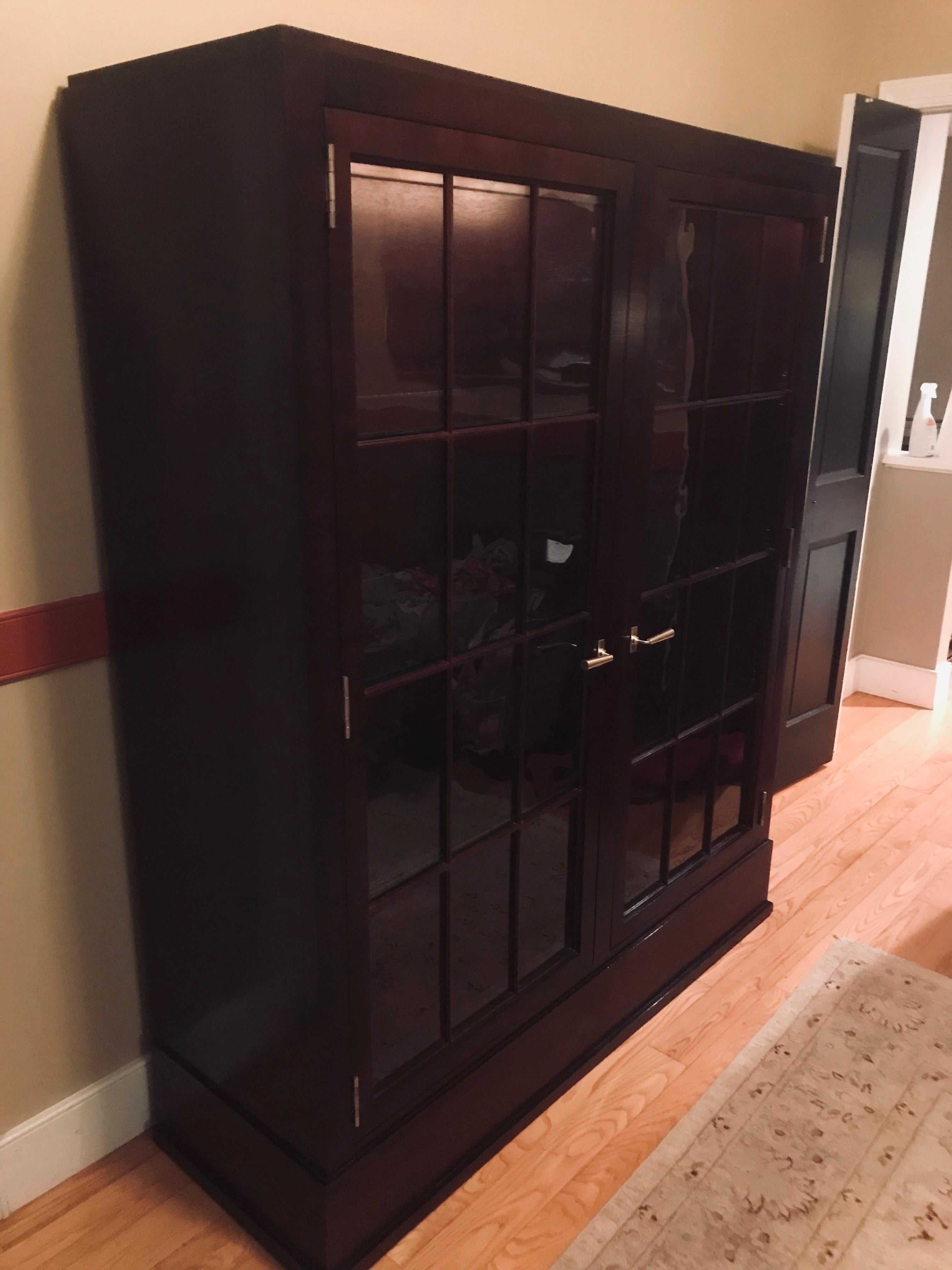 Stunning custom made mahogany cabinet with two paned glass doors and nickel hardware having adjustable shelves and interior lighting.