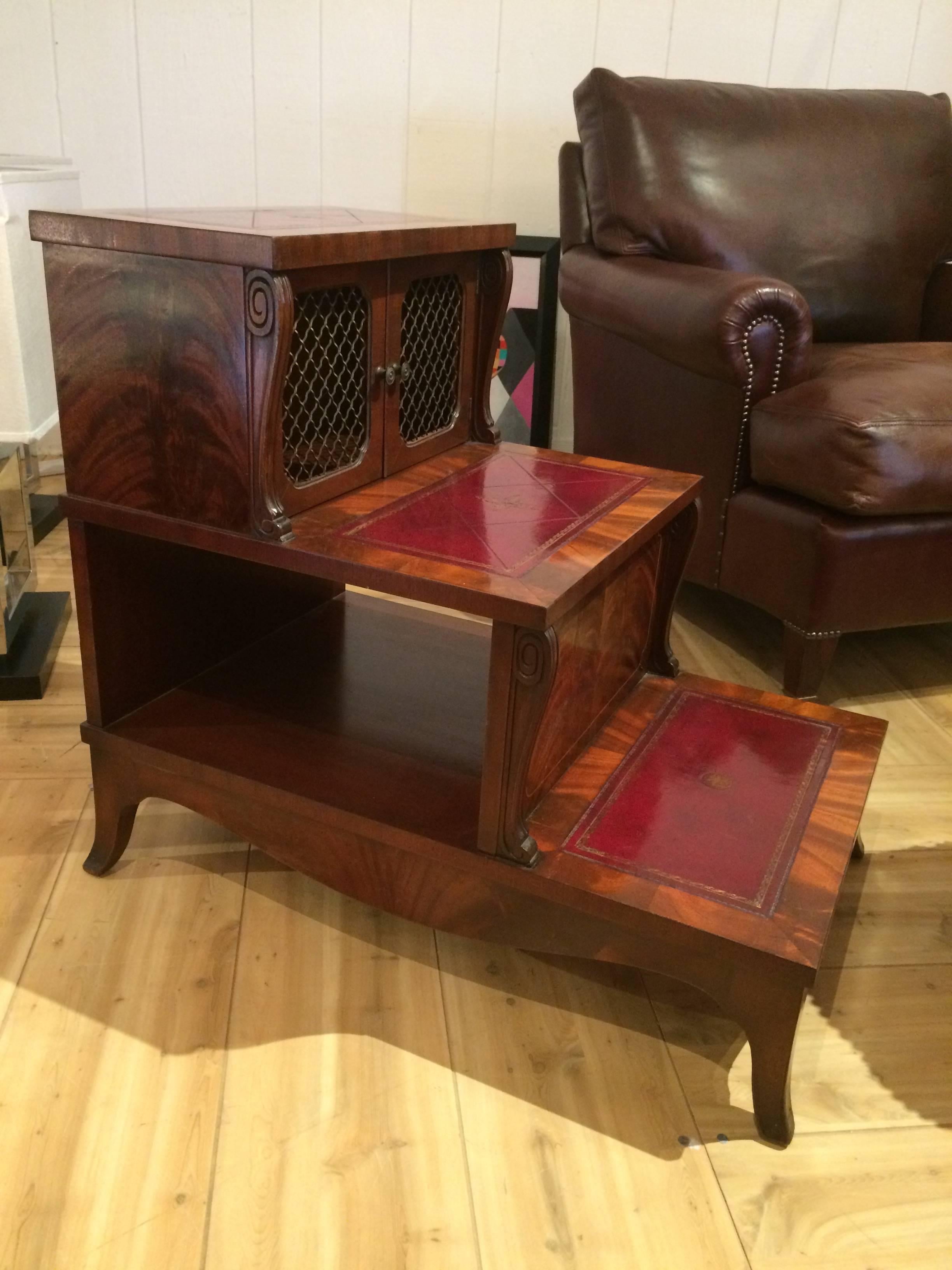 Versatile library steps having a beautiful inlaid flame mahogany structure and risers having handsome deep red tooled leather and gold decoration. The top tier has two wire mesh doors that open to storage inside, and there's an open area under the