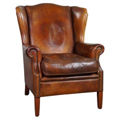 Used Very rugged wingback armchair made of cognac-colored sheep leather