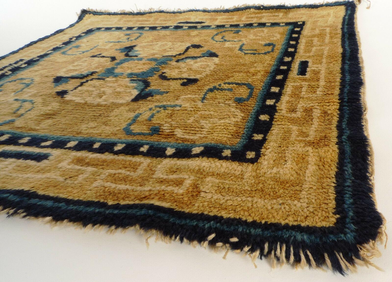 This square carpet, produced around 1800-1830, with a golden yellow field once formed part of one of the long bench covers used in Tibetan monasteries or made maybe also for a single Throne seat. The cruciform design at the centre of the field