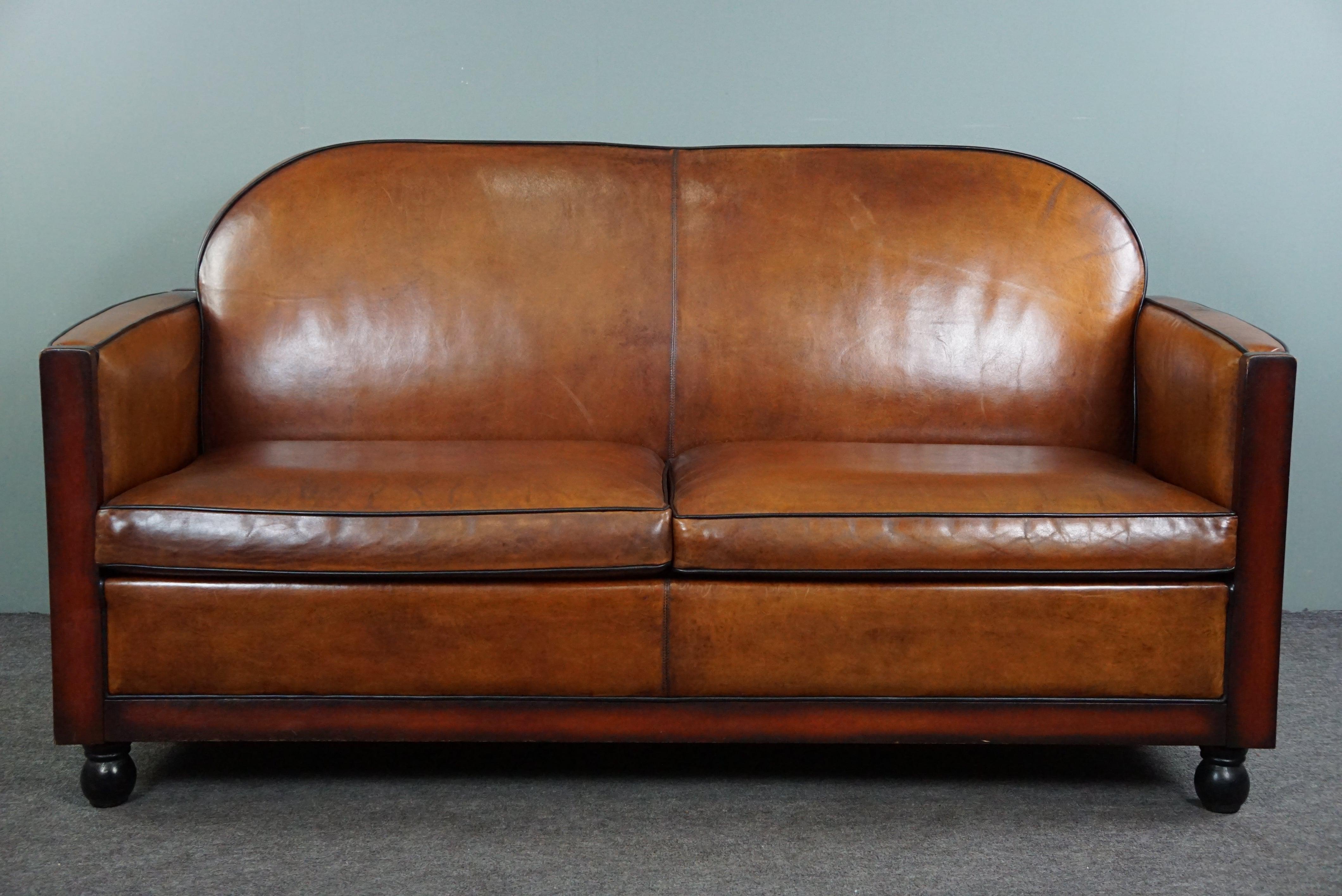 Offered is this talking sheepskin Art Deco 2.5-seater sofa in very good condition.

What colors and what a look! This beautifully sleek and well-fitting Art Deco sofa is made of sheep leather and has beautiful colors and is finished with black