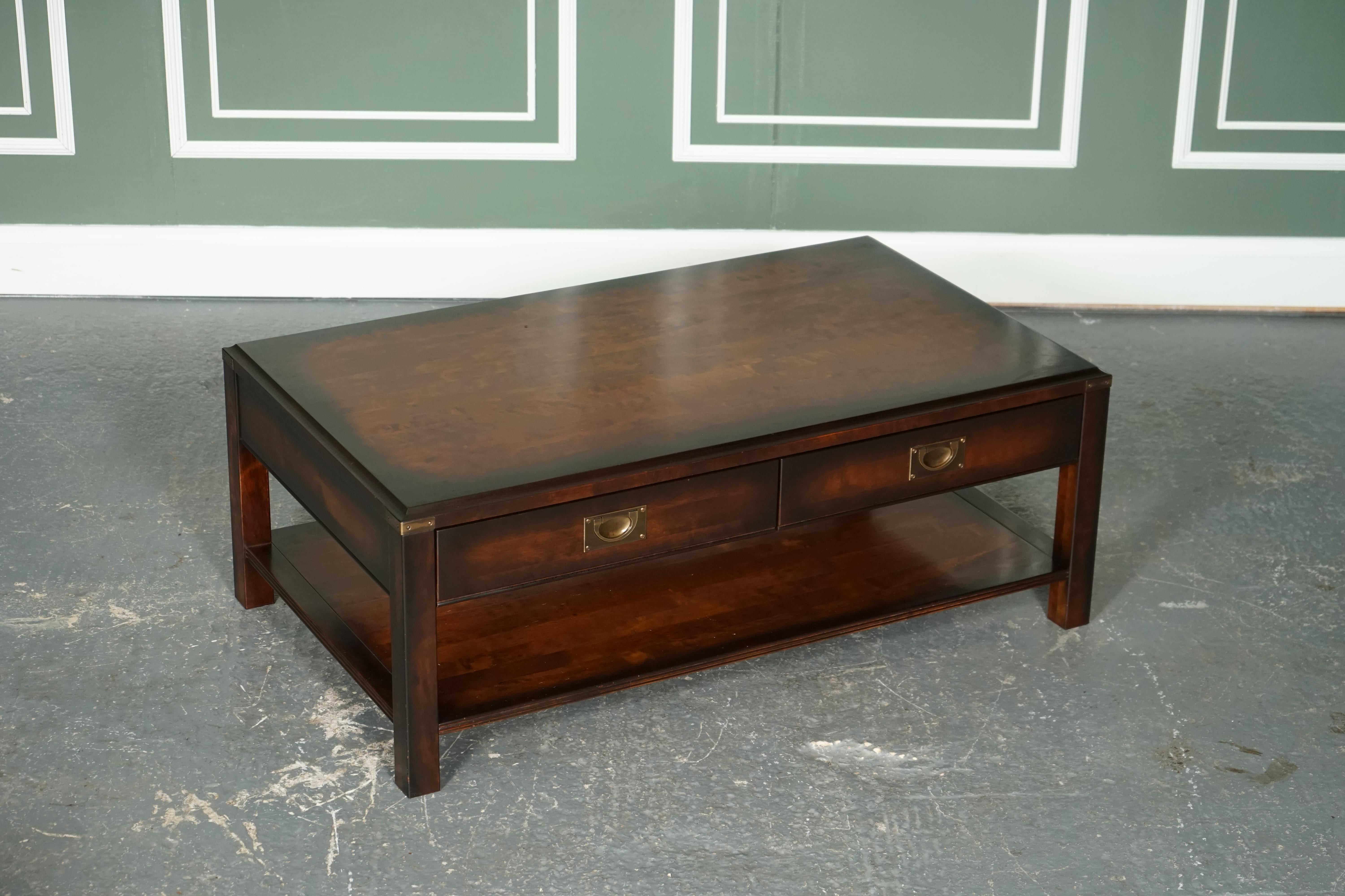 We are so excited to present to you this stunning vintage military campaign mahogany & brass coffee table.

The table has been retailed by John Lewis, you can see the plaque in one of the drawers.
Very good-looking piece with 2 drawers which work