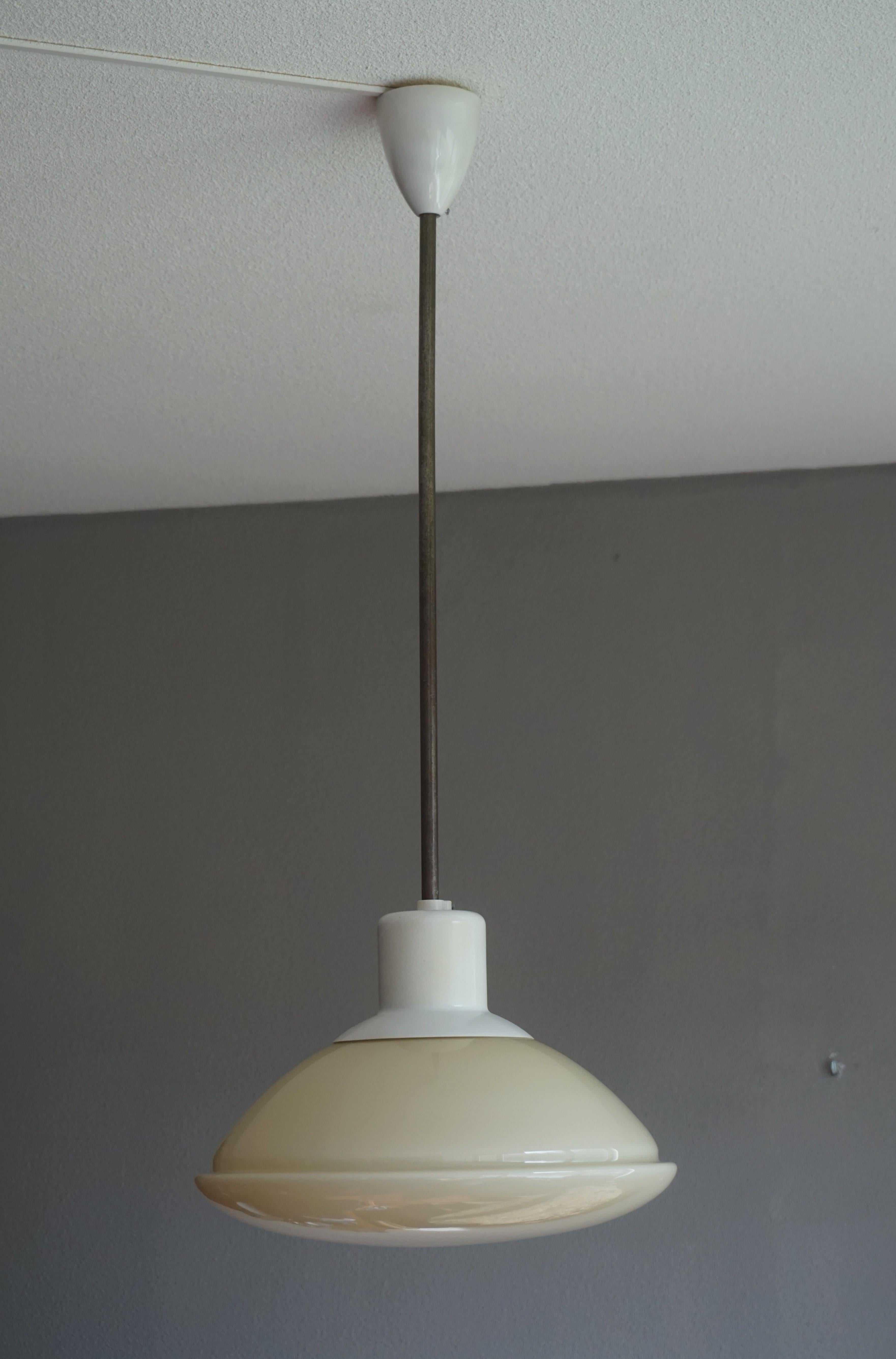 Beautiful 1950s light fixture with a mint condition, UFO shaped glass shade.

We are no specialists when it comes to Mid-Century Modern light fixtures, but whenever we get a chance to buy a truly stylish fixture from that era we will. For us, this