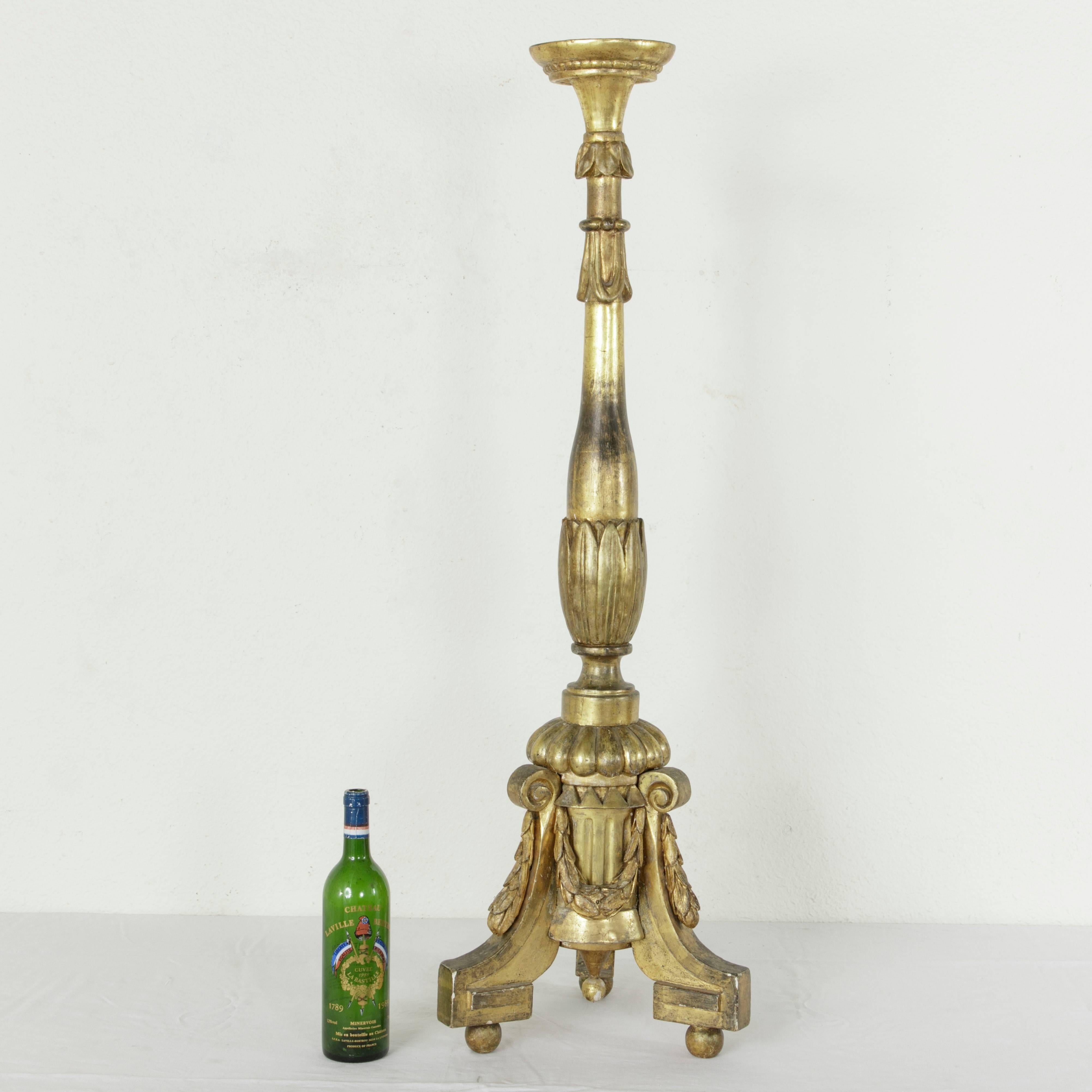 This impressively tall 19th century French Louis XVI style giltwood pricket or candlestick stands at 45 inches in height. Called a pic-cierge in French, this piece was originally used on the altar of a church in France. Hand-carved leaves adorn the