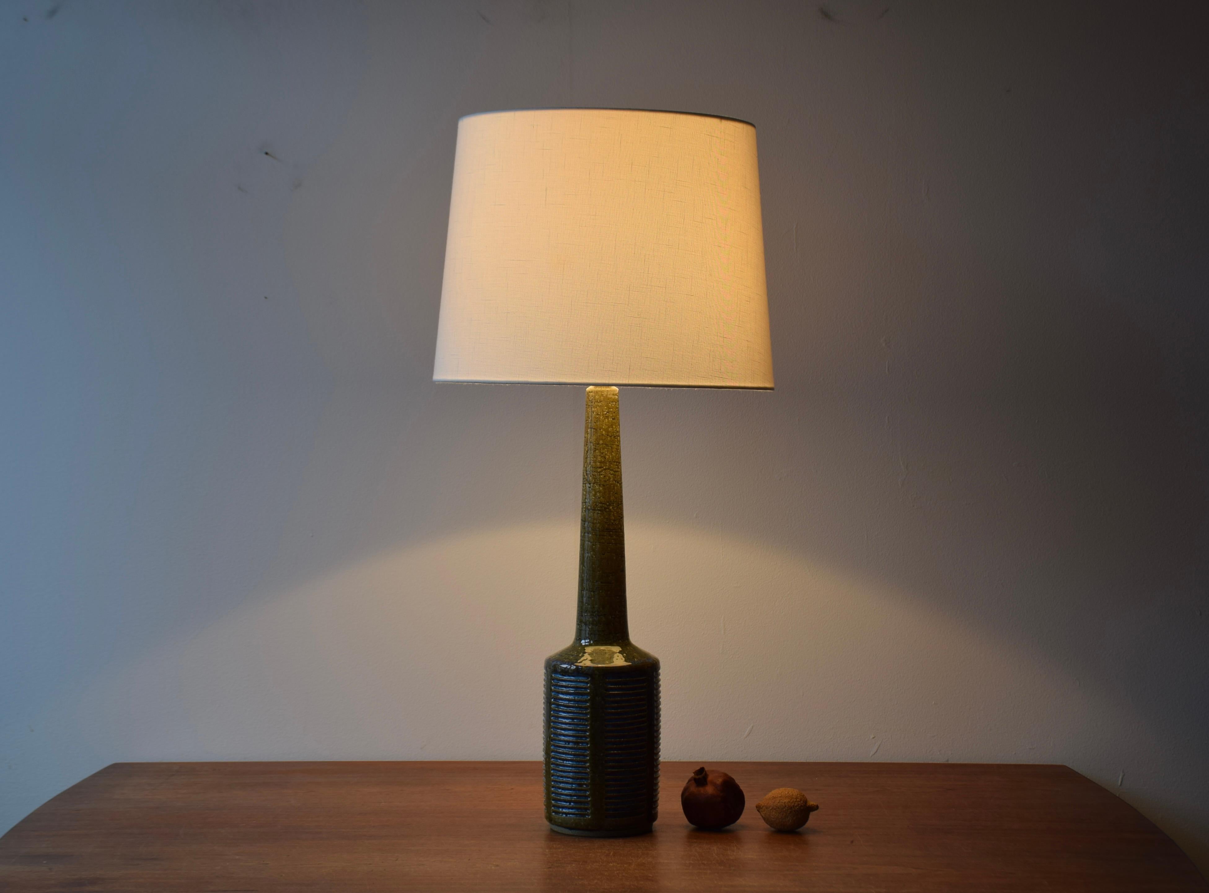 Very tall Mid-century Danish table lamp from the ceramic workshop Palshus.
The lamp was designed by Per Linnemann-Schmidt and manufactured circa 1960s.

The lamp is made with chamotte clay which gives a rough and vivid surface. The glaze is moss