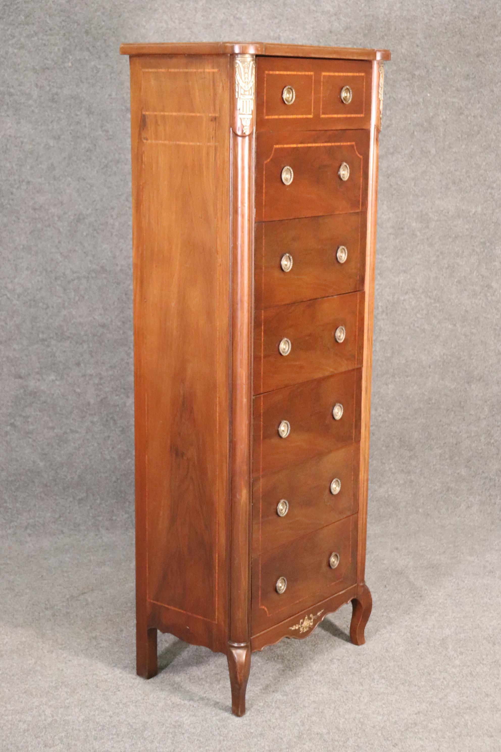 This is a very tall and useful lingerie chest. The chest is designed in the Louis XV style and in good condition with bronze mounts. The lingerie chest measures 63 tall x 24 wide x 16 deep.