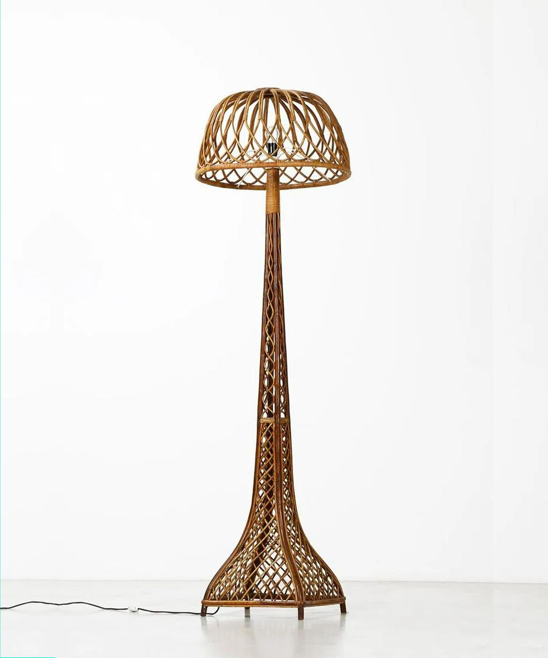 Très grand et élégant lampadaire italien en rotin. Ce rotin est habilement travaillé et tissé avec un motif dynamique en forme de croix. Les lignes fluides confèrent à cette lampe un grand intérêt visuel et un caractère ouvert et accueillant.