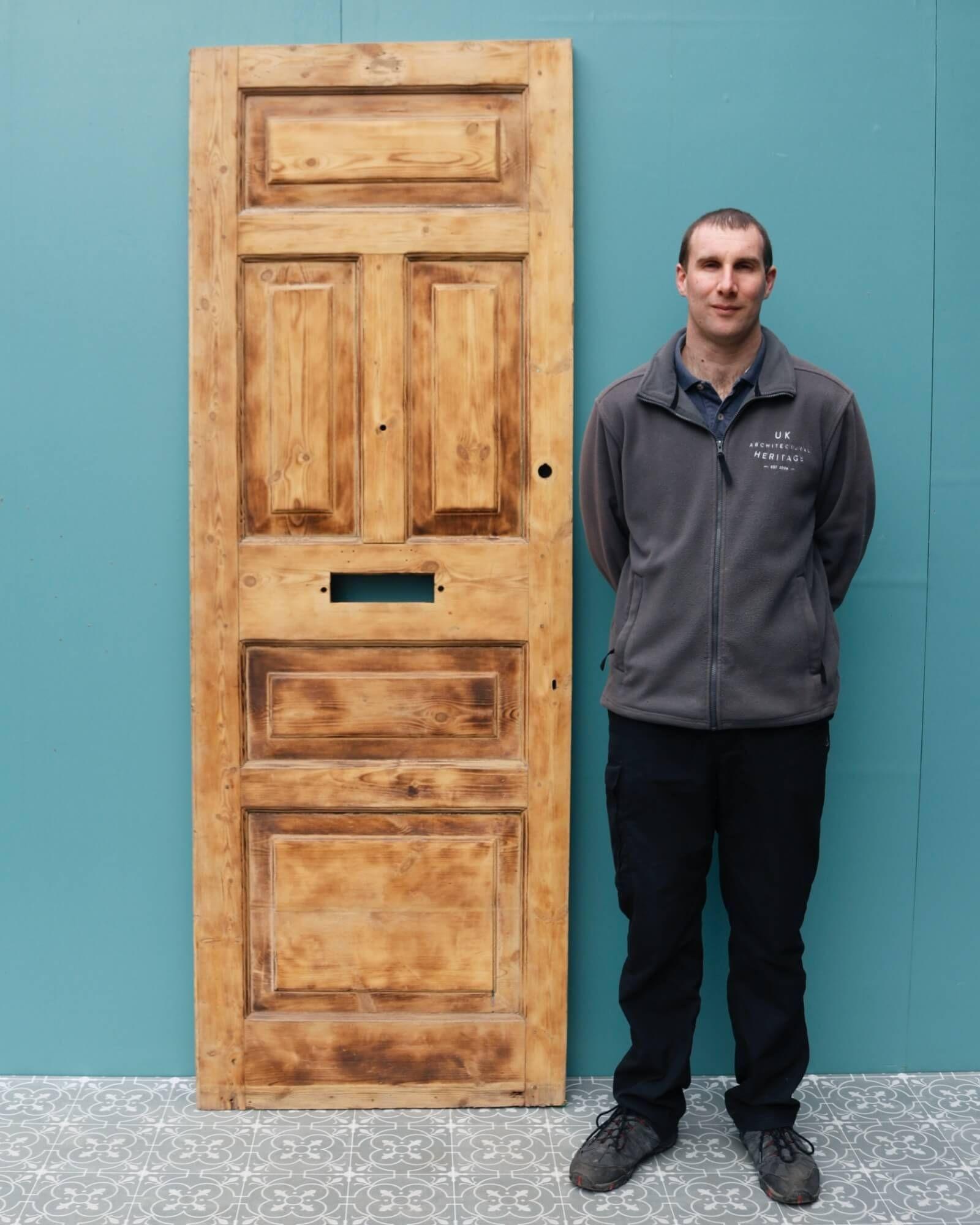 Una puerta de entrada eduardiana muy alta, recuperada, con un acabado decapado, lista para pintar, teñir o encerar en el tono deseado. Esta puerta recuperada constituye una hermosa entrada a una casa victoriana o a un apartamento eduardiano, con un