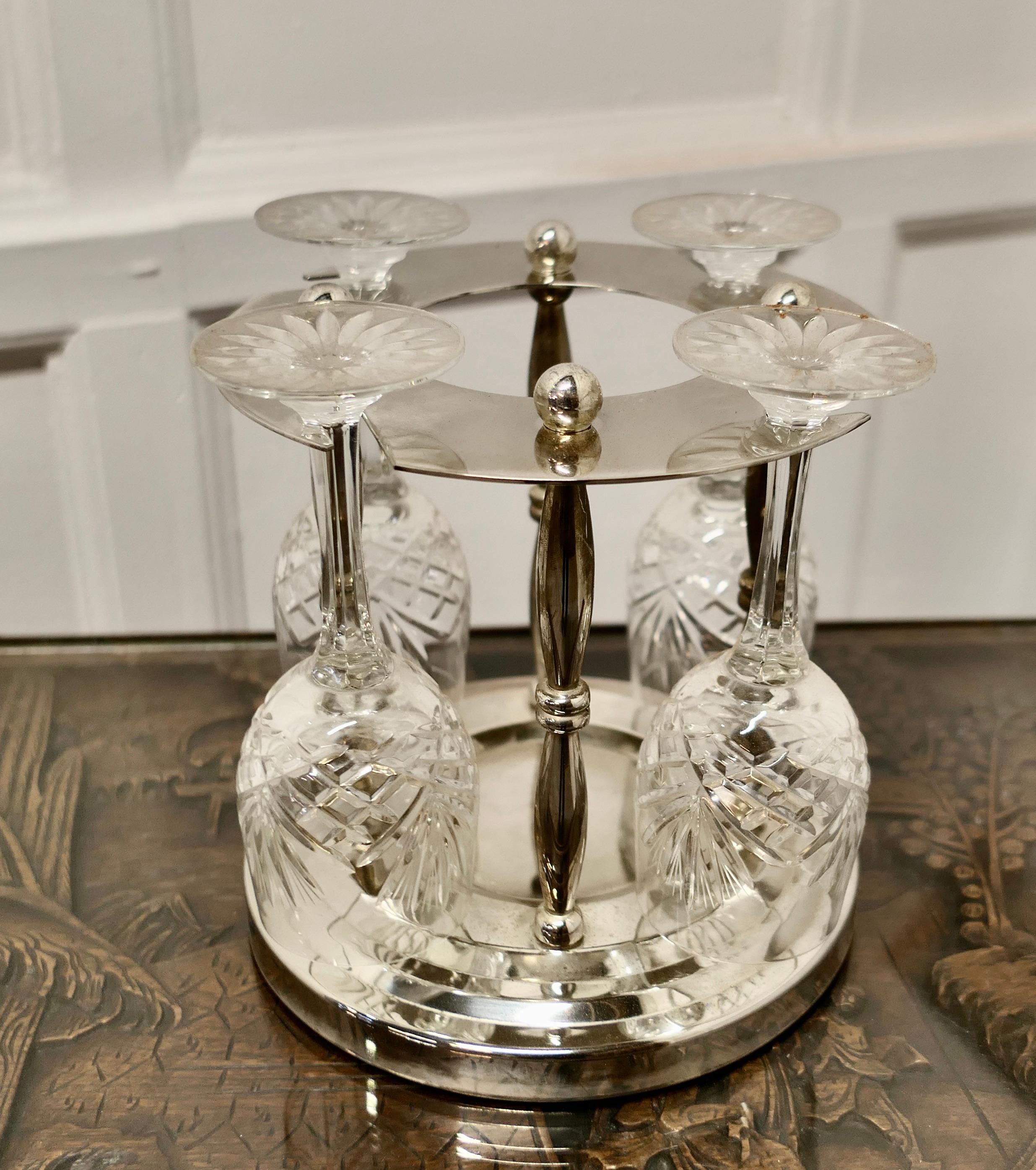 Very unusual silver plated wine coaster with crystal glasses 

A Very attractive set to present a glass of wine for 4 people, the wine bottle sits in the centre and the glasses are hung all around 
The Coaster is in silver plate the glasses are
